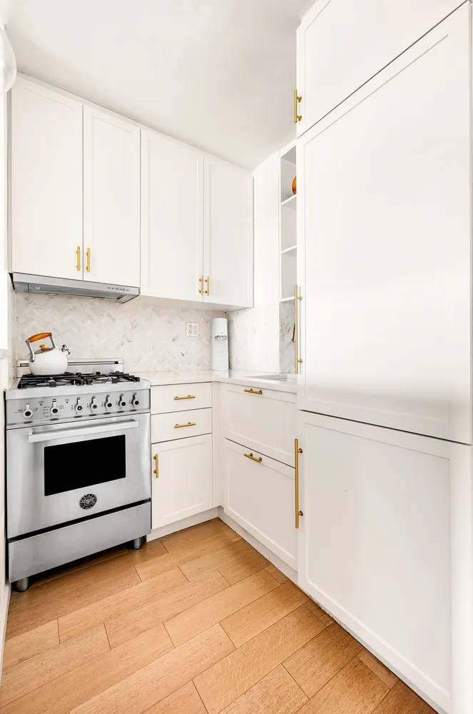 a kitchen with white cabinets and white appliances