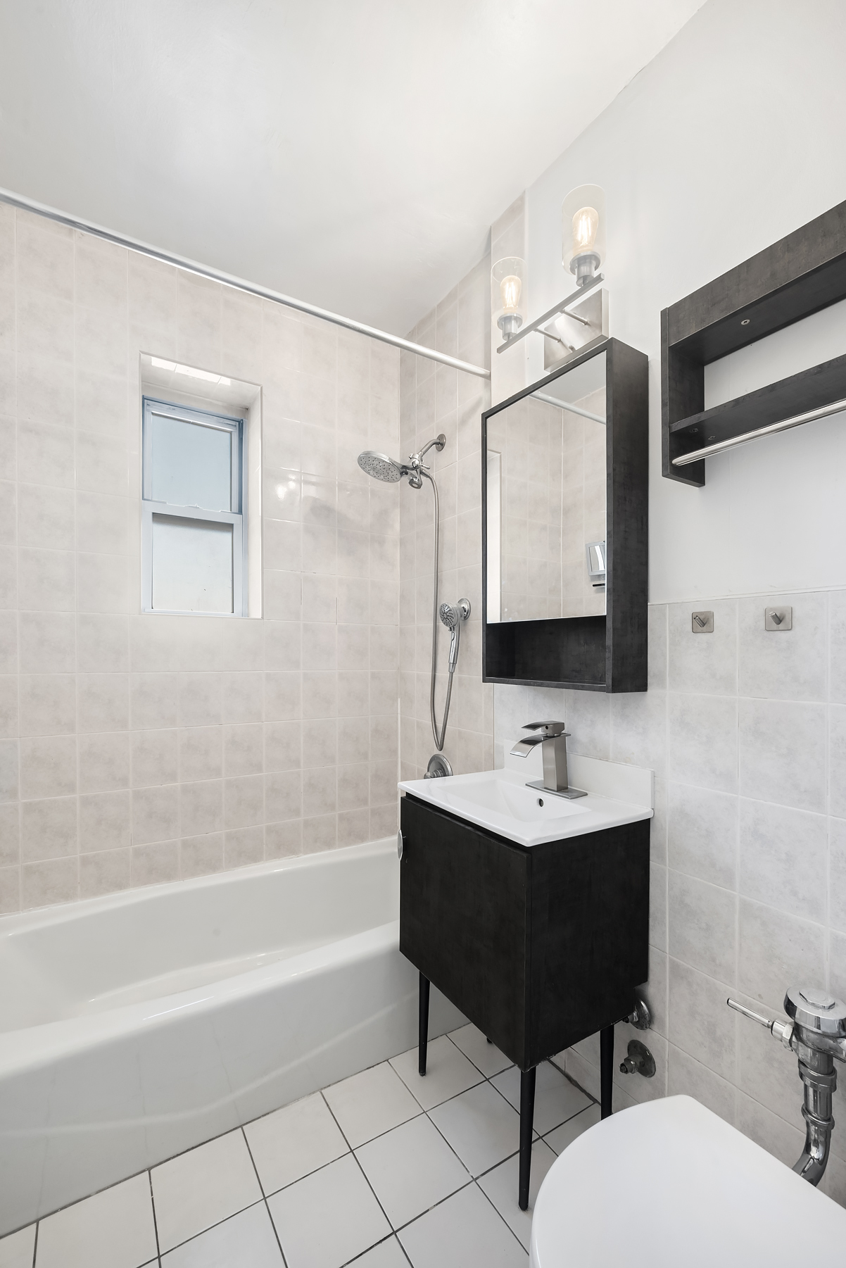 30-31 Hobart Street, Unit 3L Queens, NY 11377 - Photo 2 of 14 a bathroom with a sink mirror and a bathtub