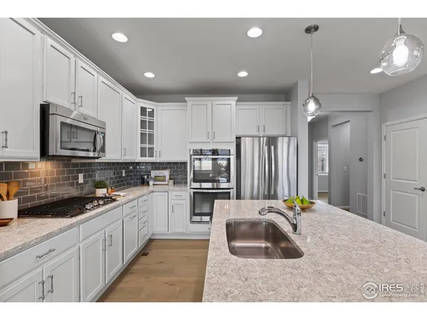 a kitchen with stainless steel appliances kitchen island sink refrigerator and cabinets