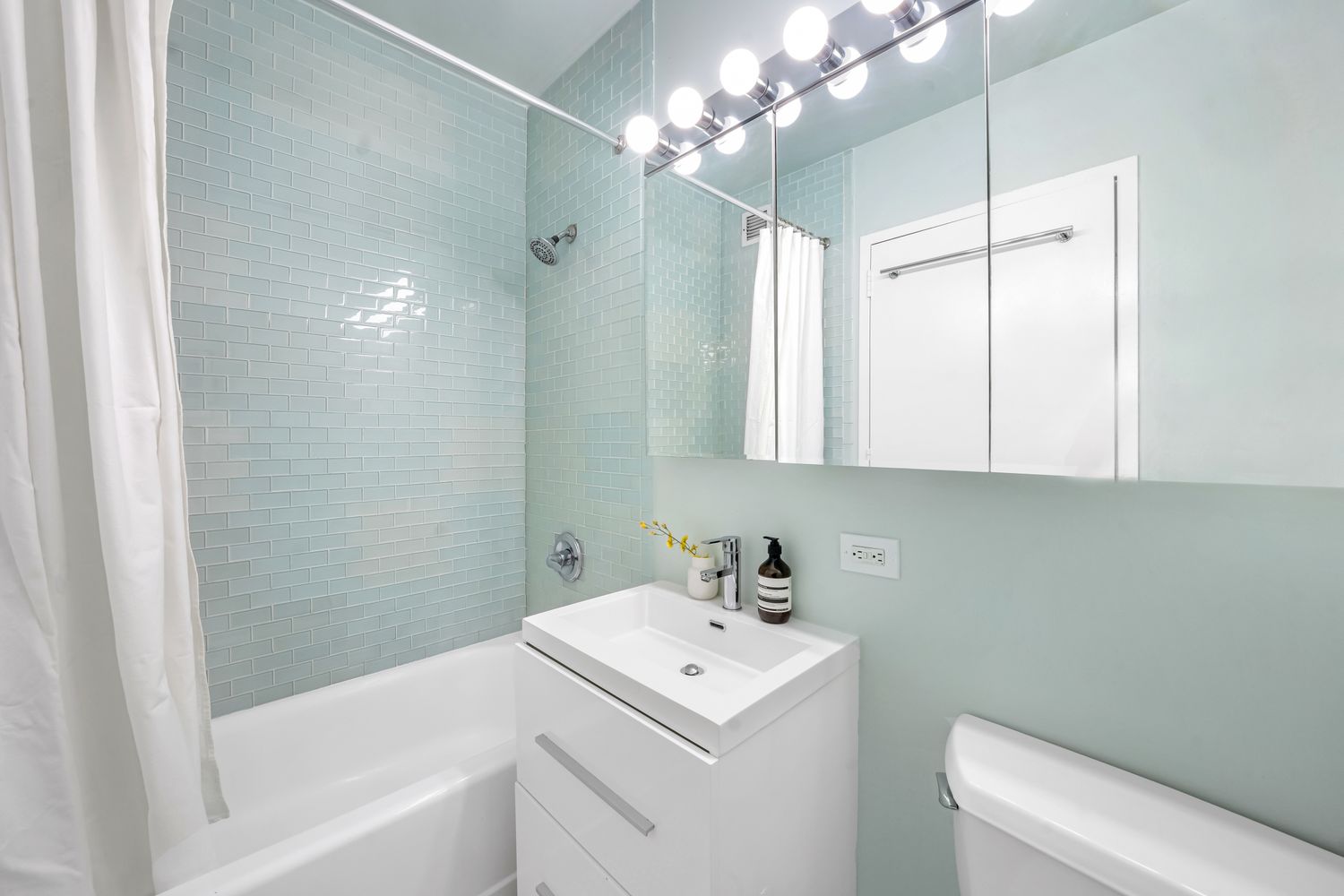 99 John Street, Unit 813 Manhattan, NY 10038 - Photo 6 of 20 a bathroom with a sink a toilet and a bathtub