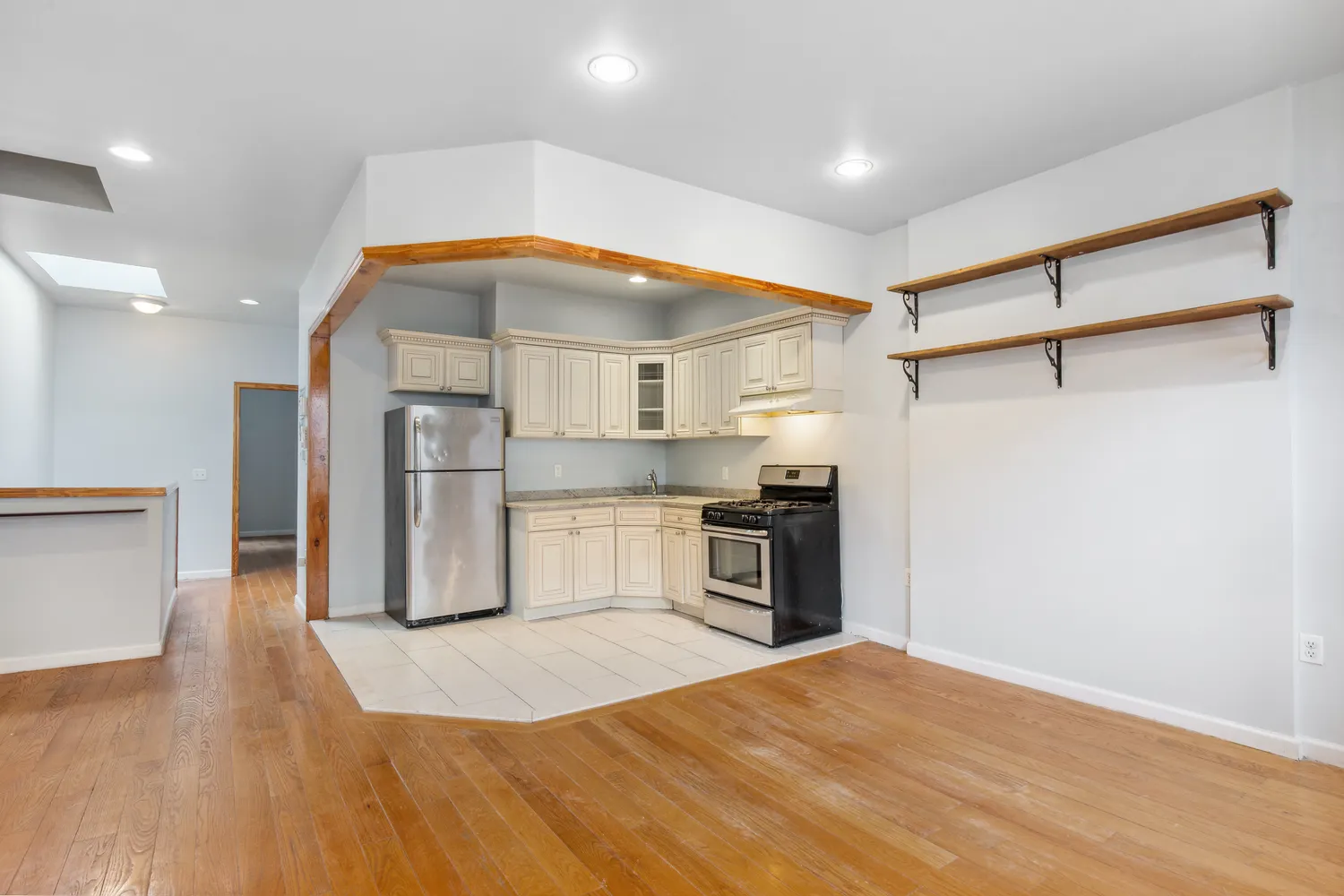 a kitchen with stainless steel appliances kitchen island granite countertop a refrigerator and a stove top oven