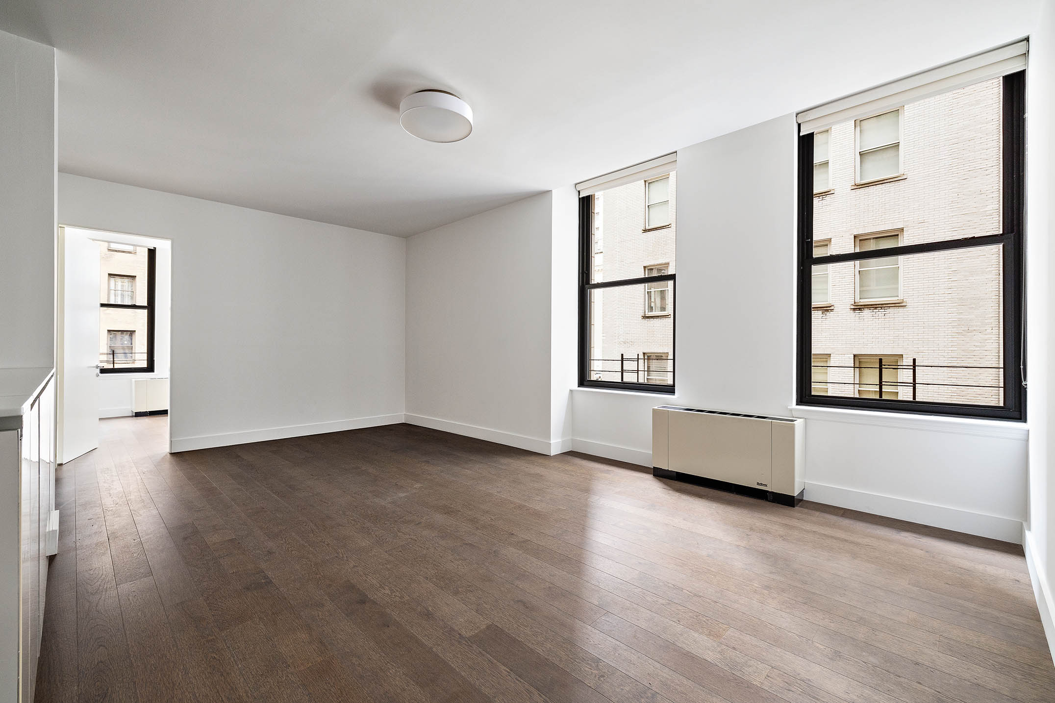 25 Broad Street, Unit 16I Manhattan, NY 10004 - Photo 2 of 23 wooden floor in an empty room with a window