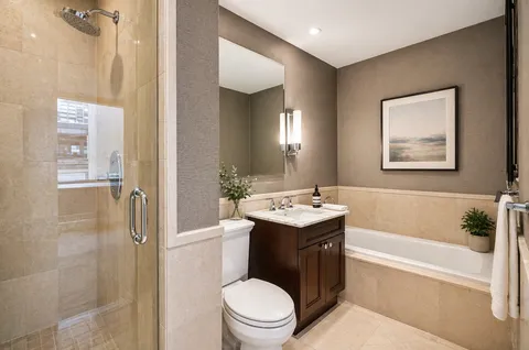 a bathroom with a granite countertop sink toilet and shower