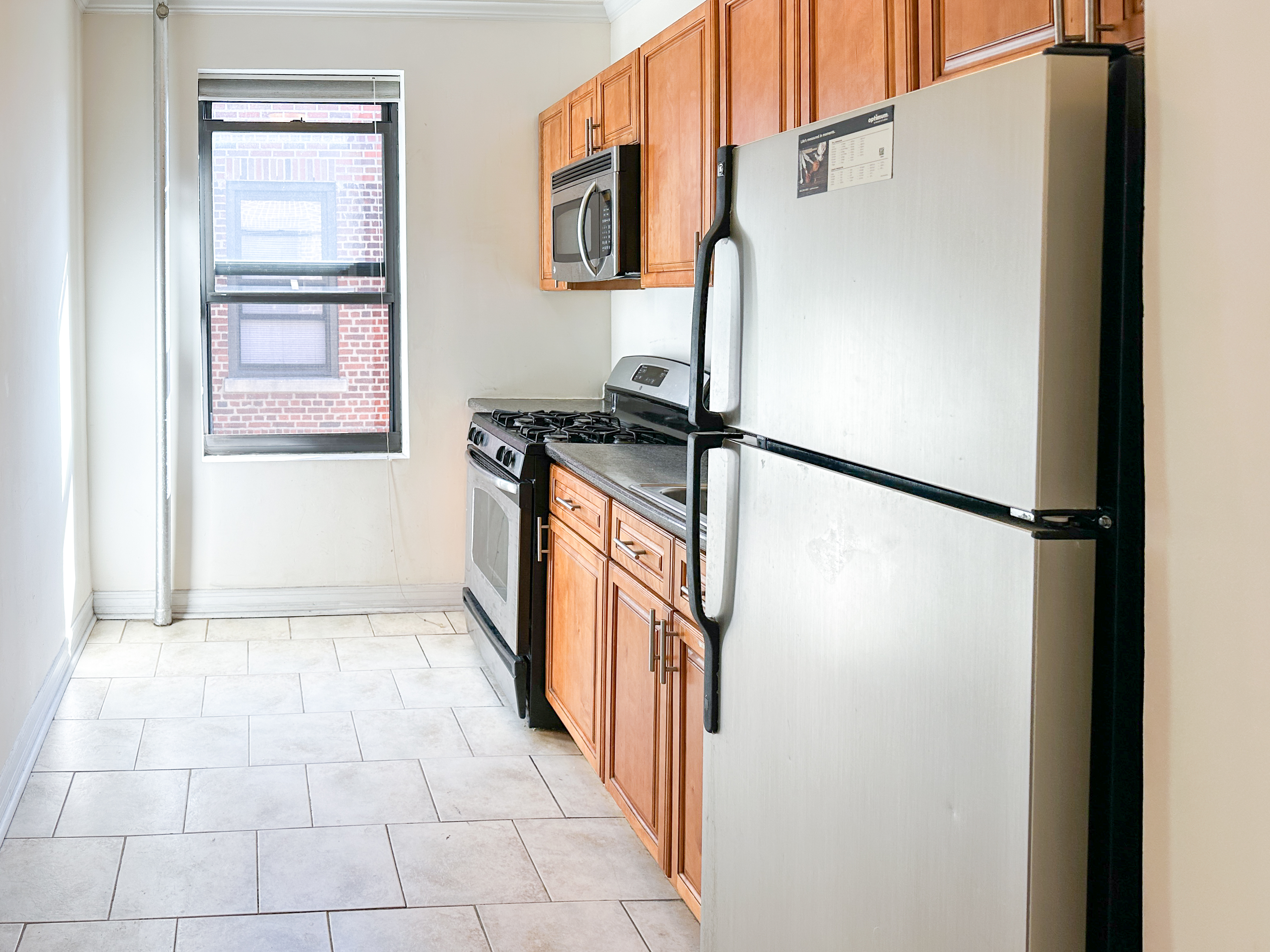 1506 Overing Street, Unit 1D Bronx, NY 10461 - Photo 9 of 10 a kitchen with stainless steel appliances granite countertop a refrigerator and a stove