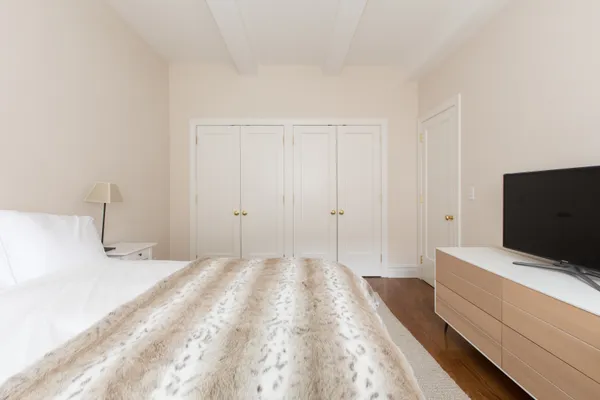 a view of bedroom with wooden floor and flat screen tv