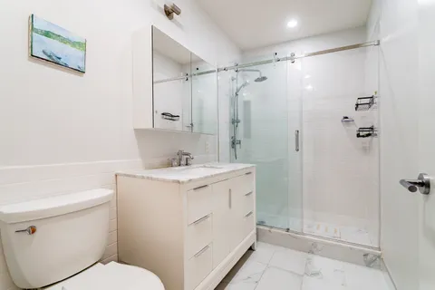 a bathroom with a granite countertop sink toilet and shower