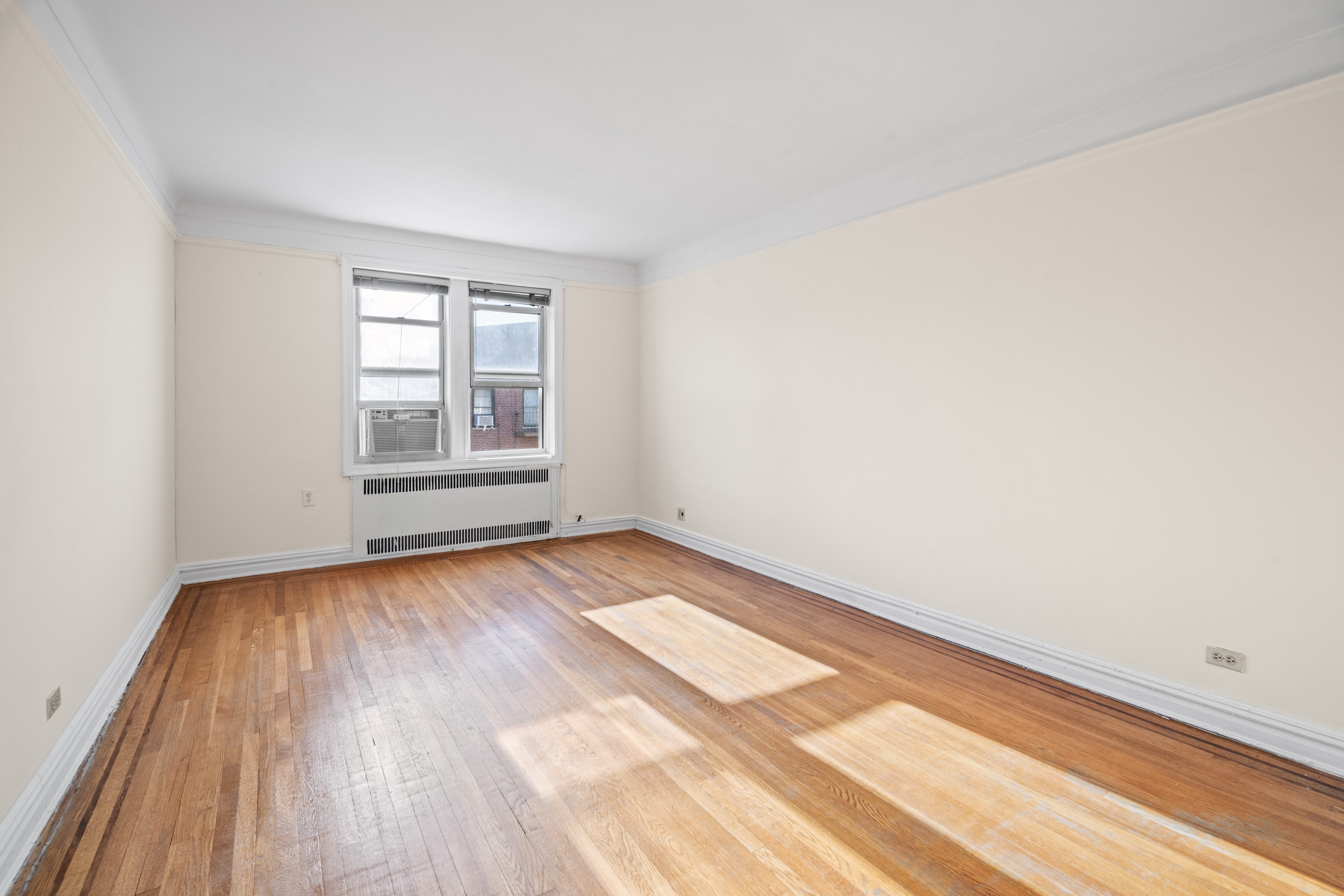 40 Tehama Street, Unit 6E Brooklyn, NY 11218 - Photo 3 of 16 an empty room with wooden floor and windows