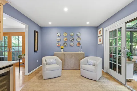 a dining room with stainless steel appliances kitchen island granite countertop a table chairs and a refrigerator