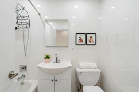 a bathroom with a toilet sink and mirror