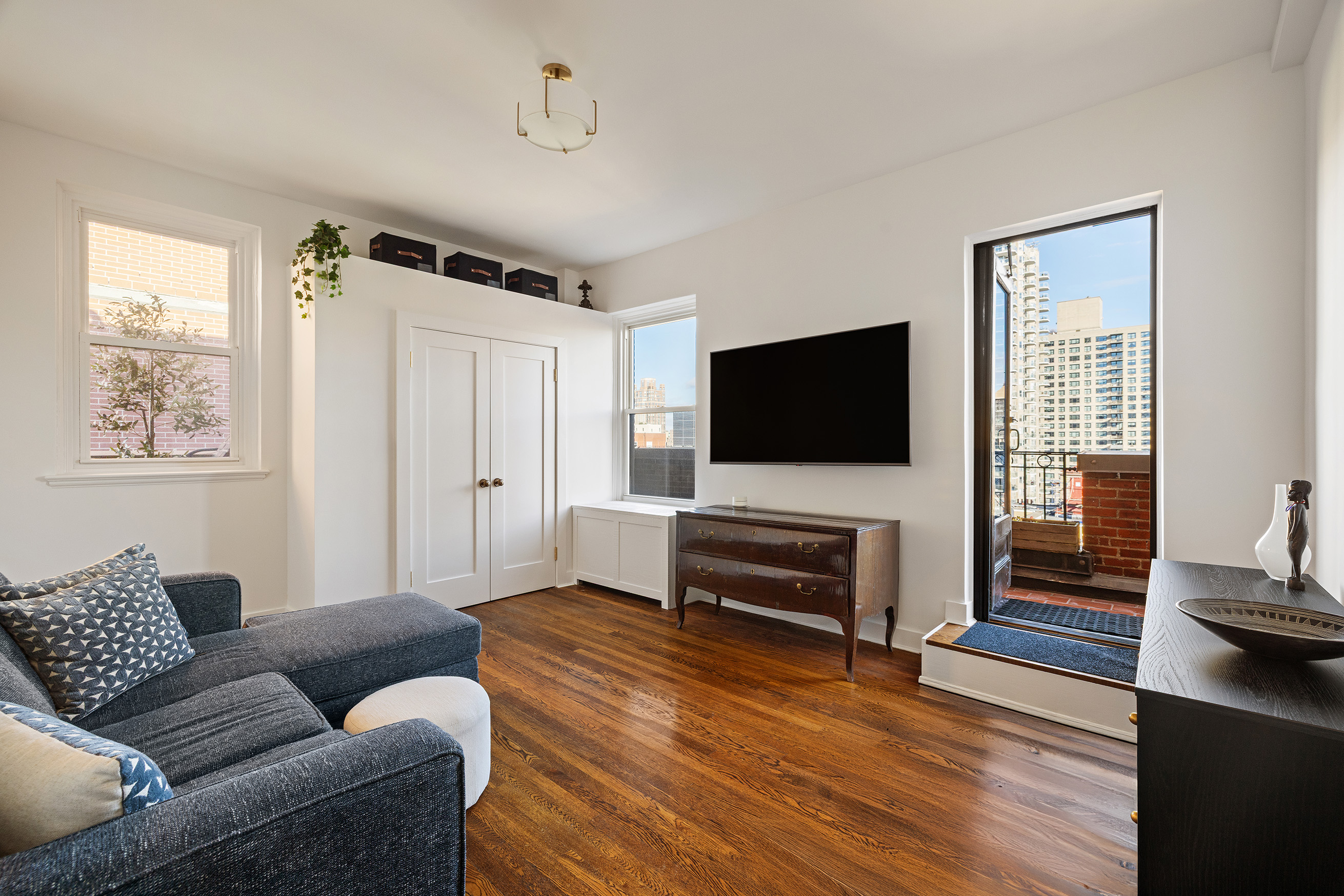 320 East 72nd Street, Unit PHB Manhattan, NY 10021 - Photo 11 of 26 a living room with furniture and a flat screen tv