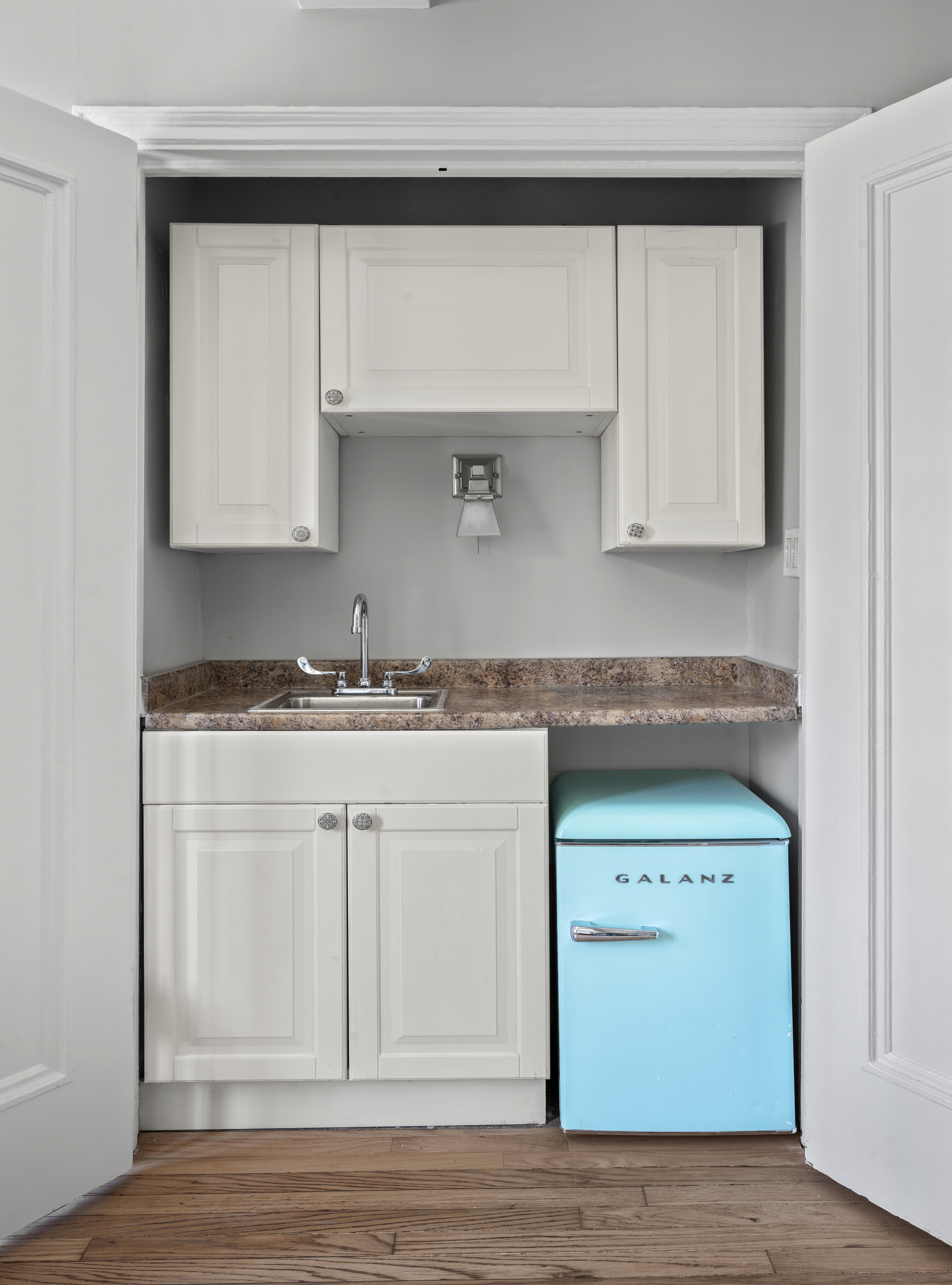 25 Tudor City Place, Unit 303 Manhattan, NY 10017 - Photo 5 of 6 a kitchen with granite countertop white cabinets and a sink
