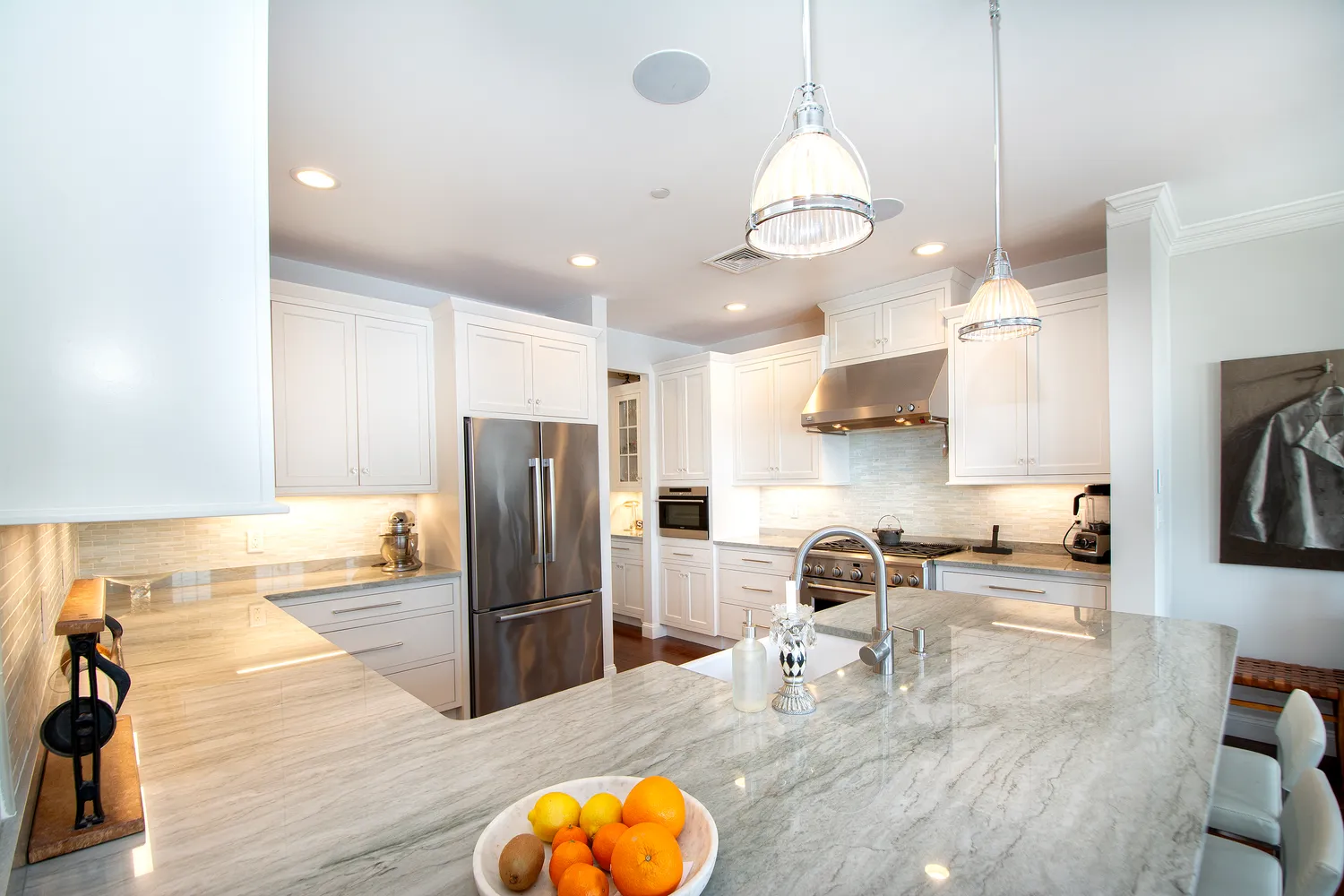 a living room with stainless steel appliances kitchen island granite countertop furniture and a chandelier