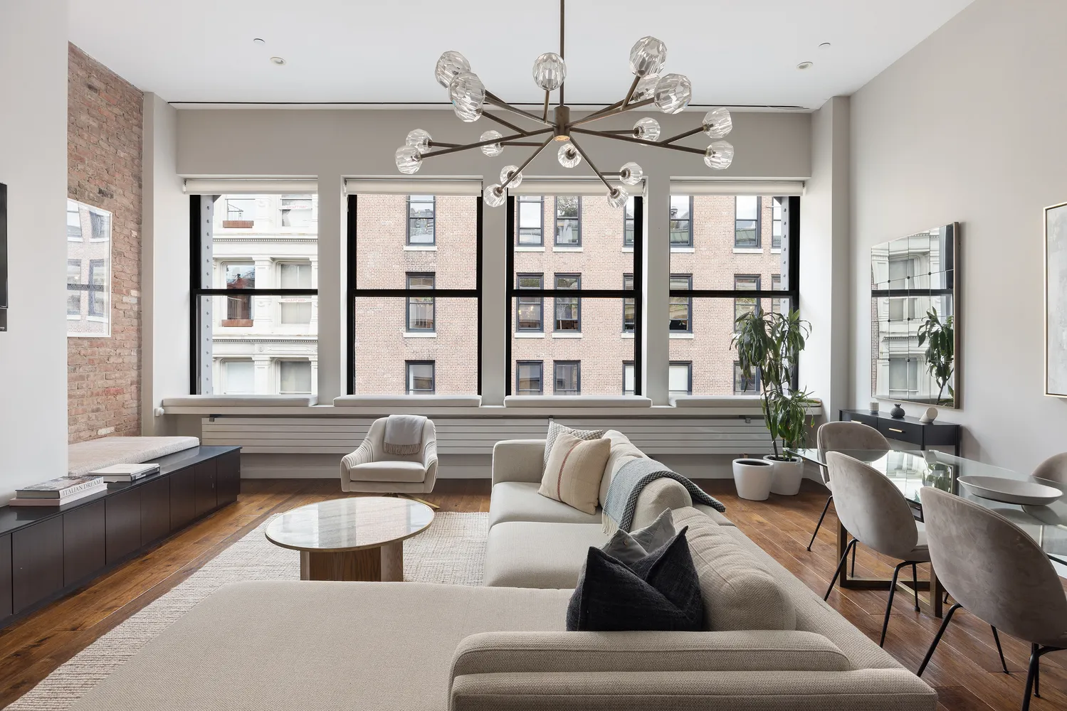 a living room with furniture kitchen view and large windows