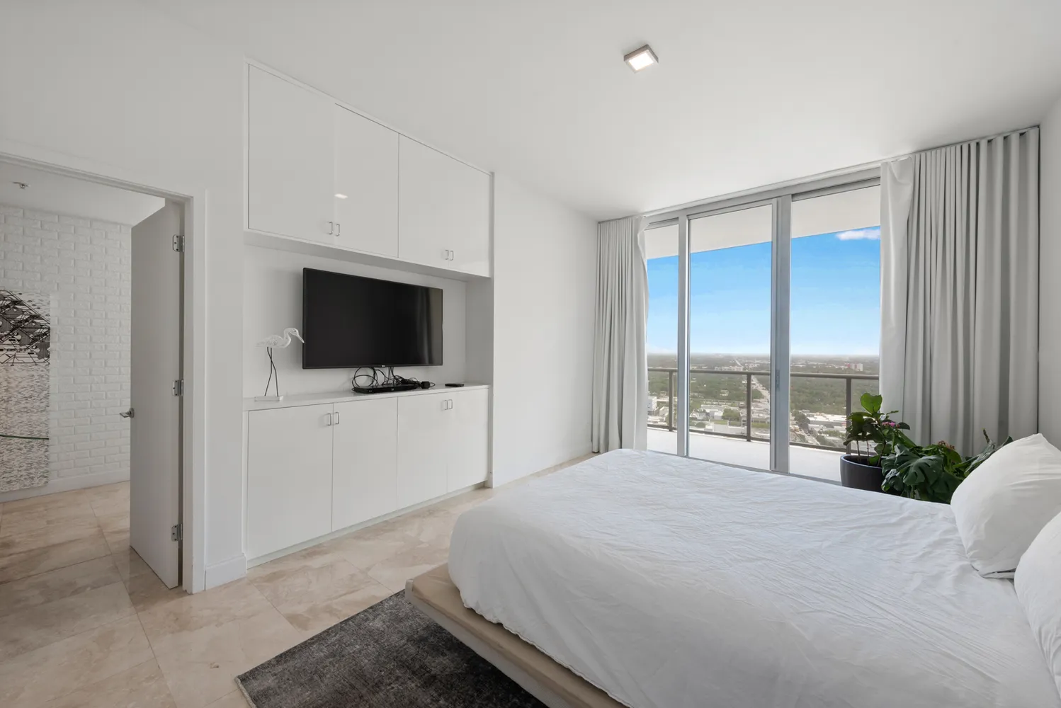 a bedroom with a large bed and a flat screen tv