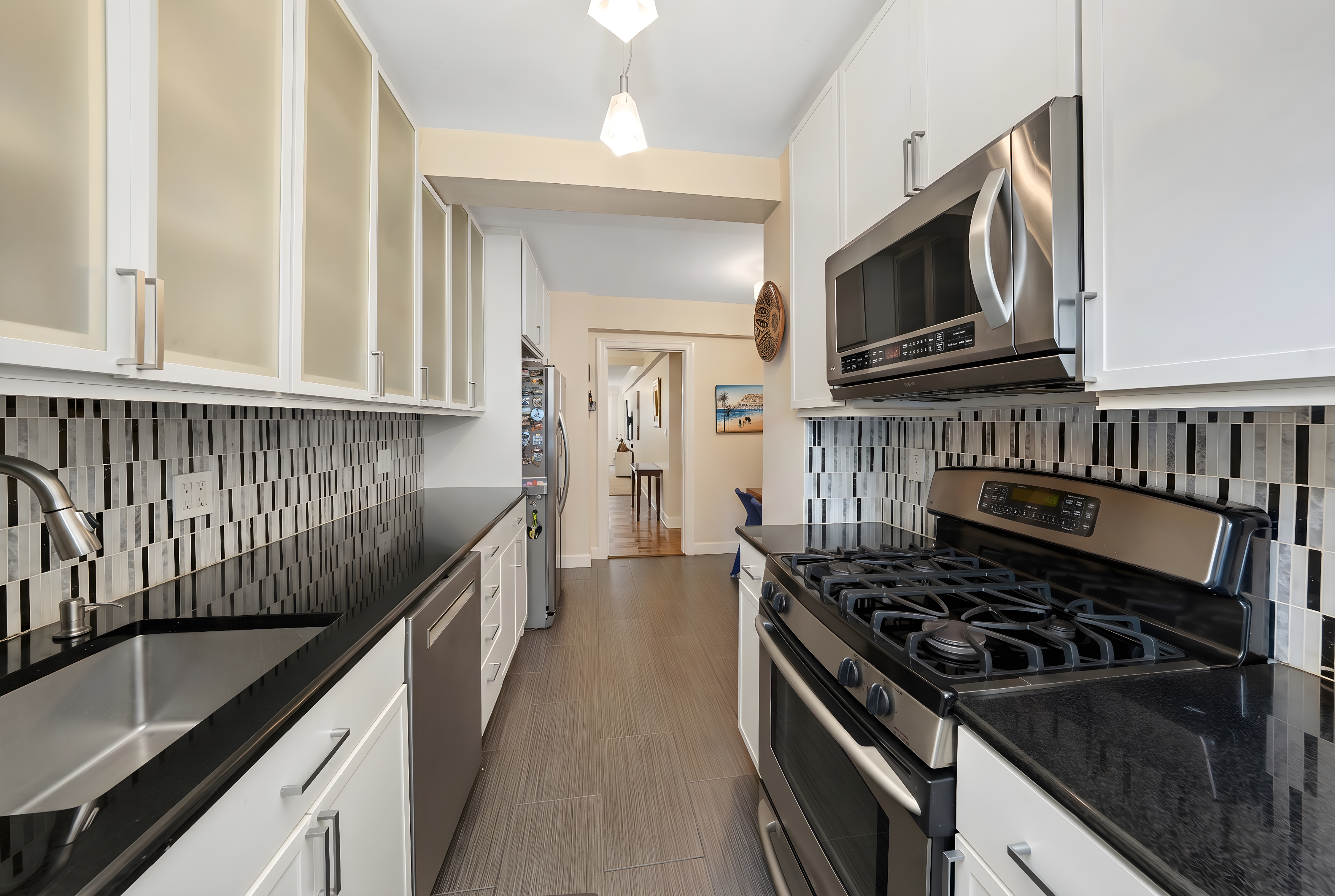 345 East 56th Street, Unit 7J Manhattan, NY 10022 - Photo 7 of 13 a kitchen with stainless steel appliances granite countertop a stove and a microwave