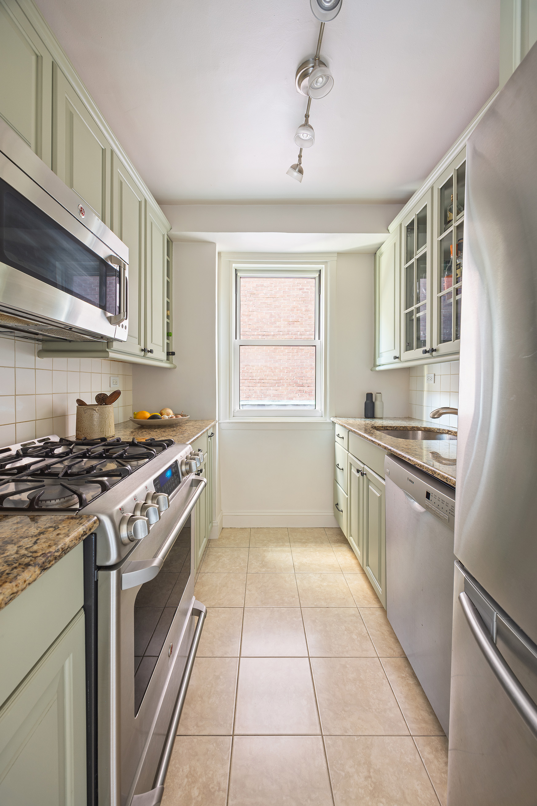 123 East 75th Street, Unit 6B Manhattan, NY 10021 - Photo 6 of 13 a kitchen with a stove top oven sink and cabinets