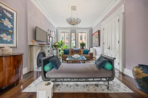 a living room with furniture a fireplace and a chandelier