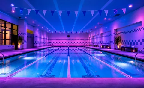a view of swimming pool with red chairs