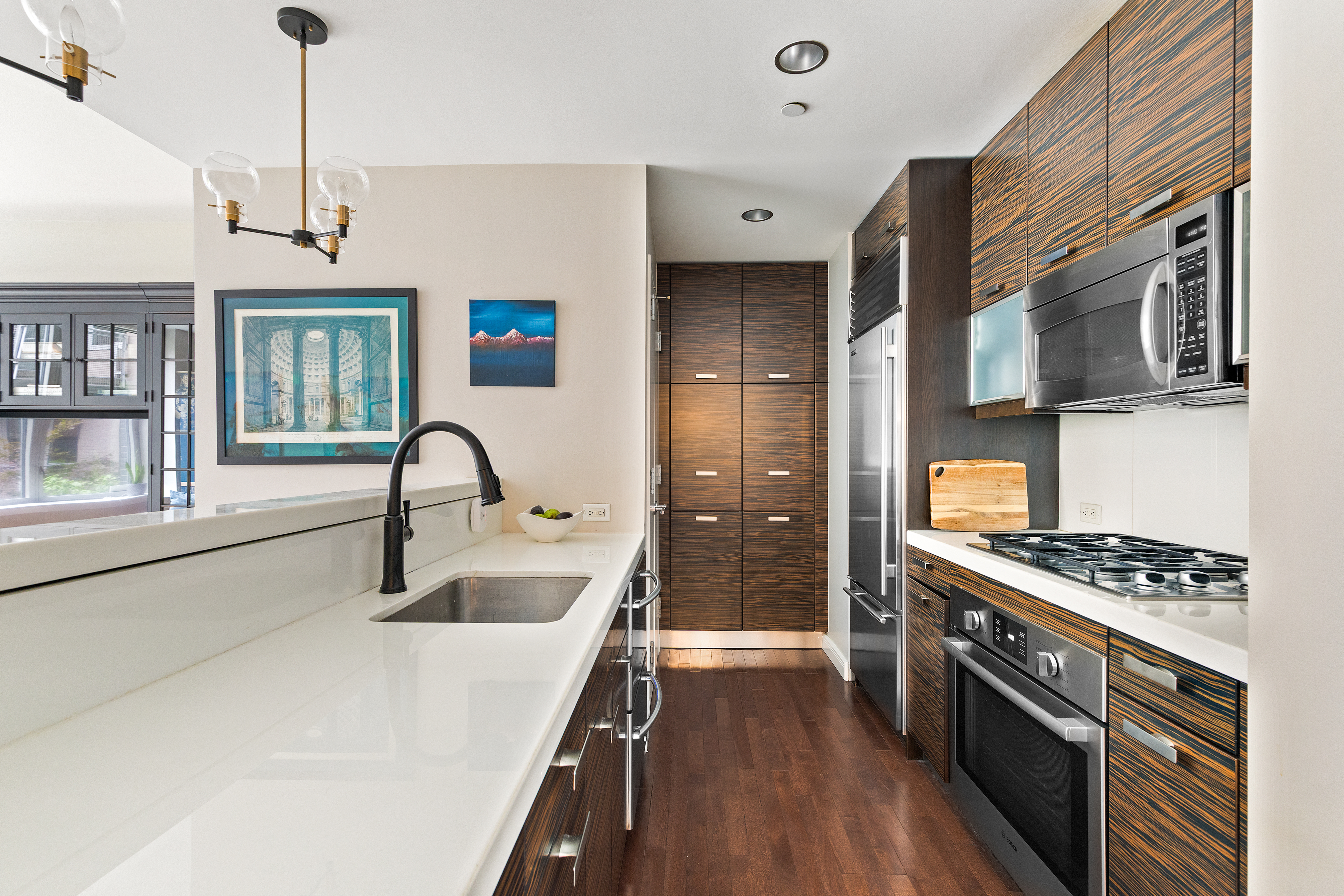 225 East 34th Street, Unit 3K Manhattan, NY 10016 - Photo 4 of 19 a kitchen with stainless steel appliances granite countertop a sink and a stove top oven