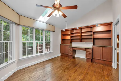 a kitchen with stainless steel appliances granite countertop a refrigerator a stove and a sink with wooden floors