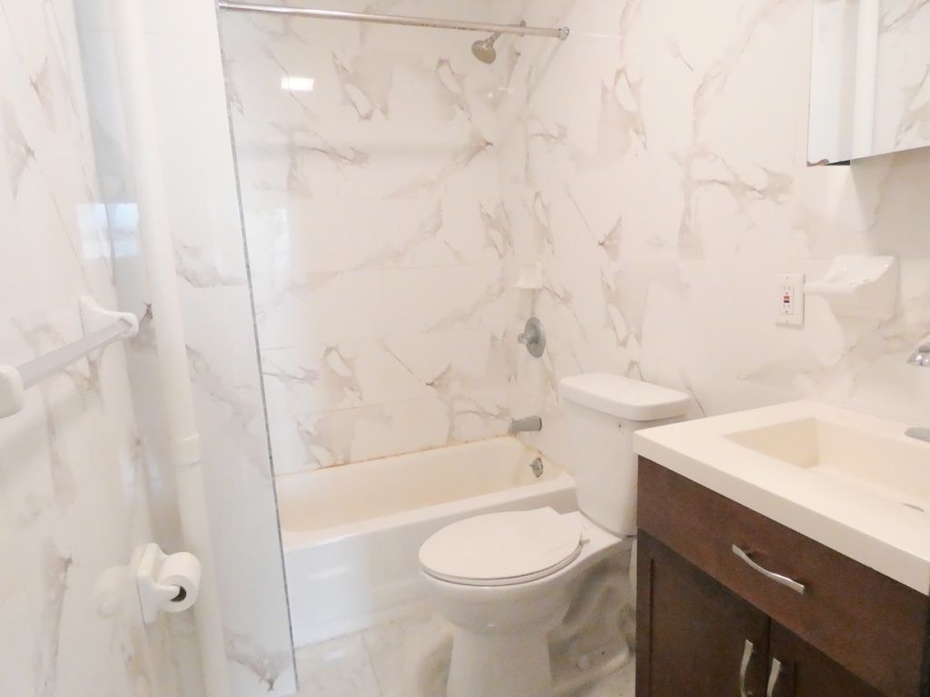 1773 1st Avenue, Unit 9 Manhattan, NY 10128 - Photo 3 of 5 a bathroom with a sink a toilet and shower
