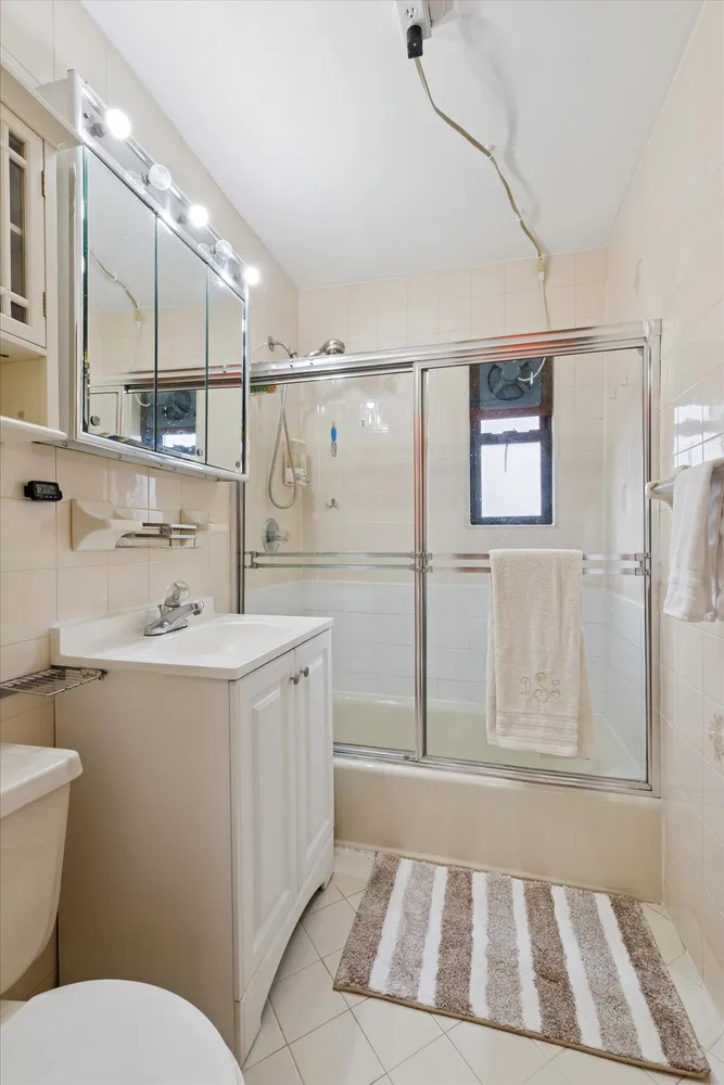 a bathroom with a sink a toilet a mirror and shower