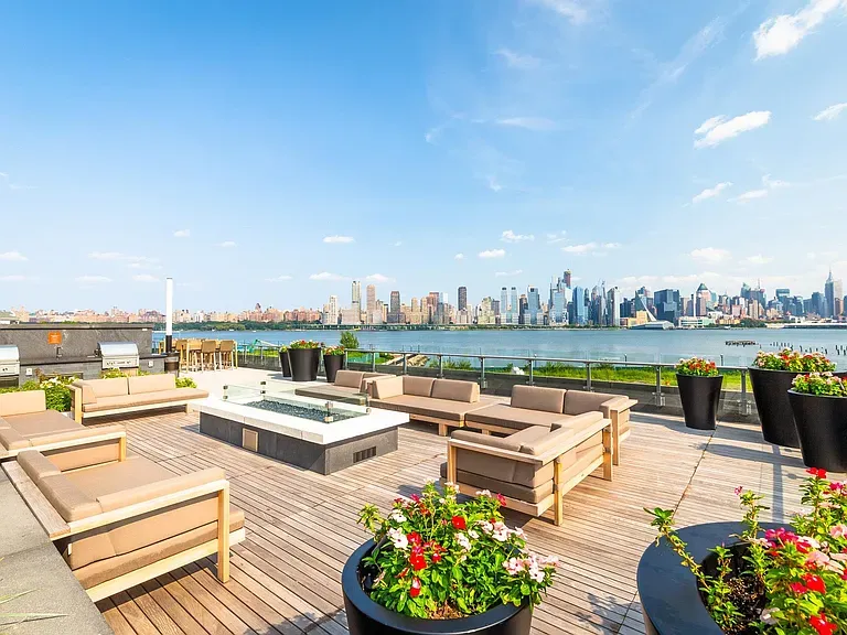 a view of a roof deck with couches and lounge chairs