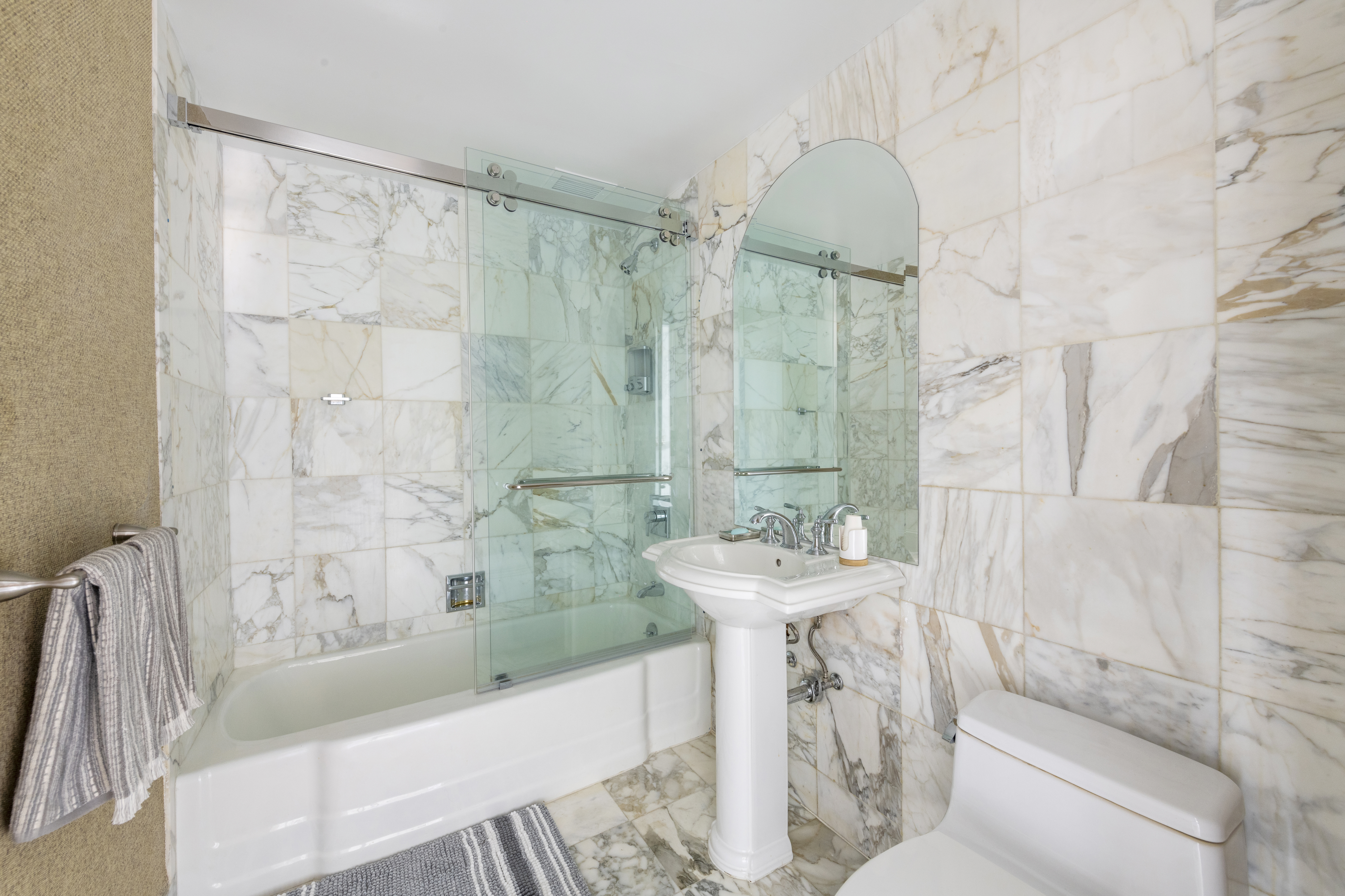 870 United Nations Plaza, Unit 15E Manhattan, NY 10017 - Photo 11 of 19 a bathroom with a sink a mirror a bathtub and shower