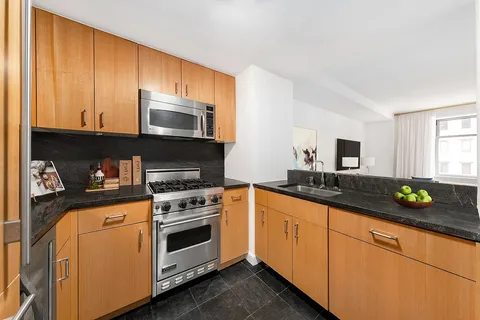 a kitchen with stainless steel appliances granite countertop a stove a sink and a microwave