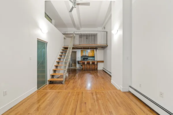 a view of a hallway with wooden floor and staircase