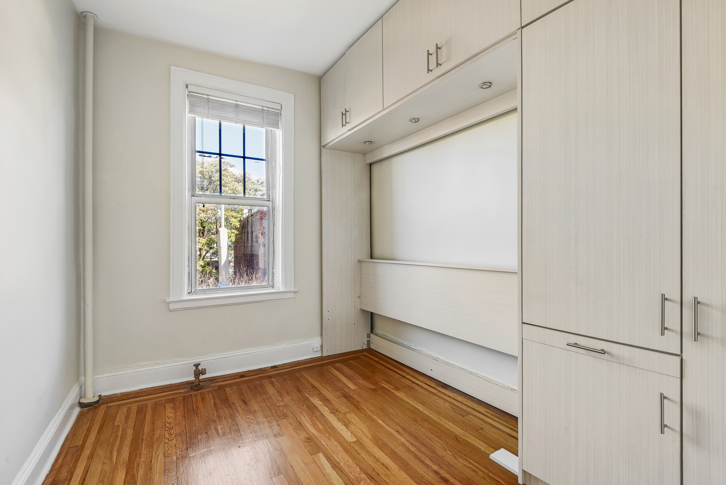 344 West 12th Street, Unit 5C Manhattan, NY 10014 - Photo 5 of 11 a view of an empty room with wooden floor and a window