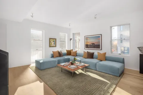 a living room with furniture wooden floor and window