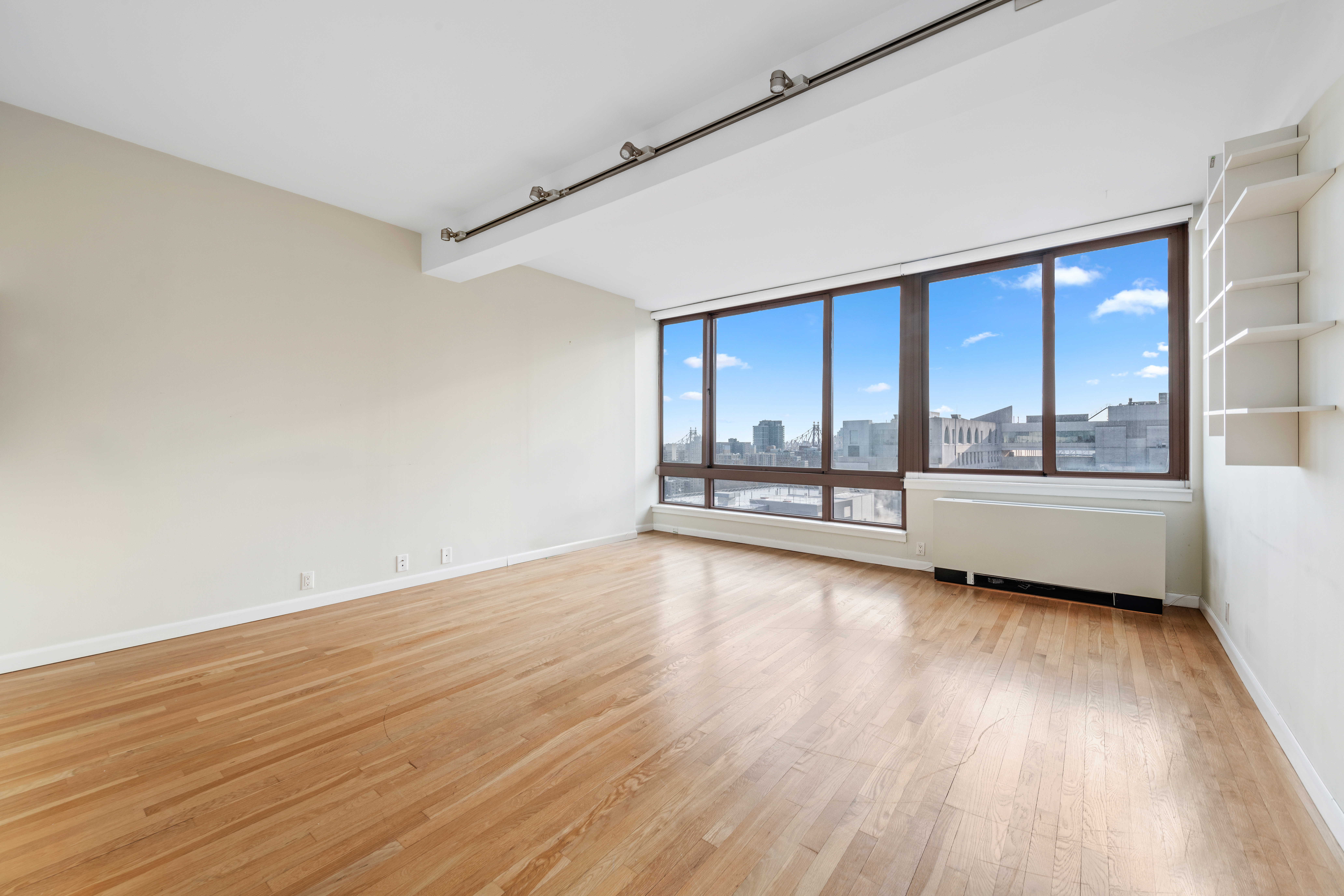524 East 72nd Street, Unit 24A Manhattan, NY 10021 - Photo 2 of 12 wooden floor in an empty room with a window