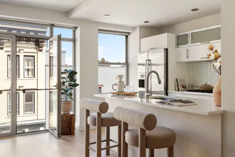 a kitchen with stainless steel appliances kitchen island granite countertop a refrigerator and white cabinets