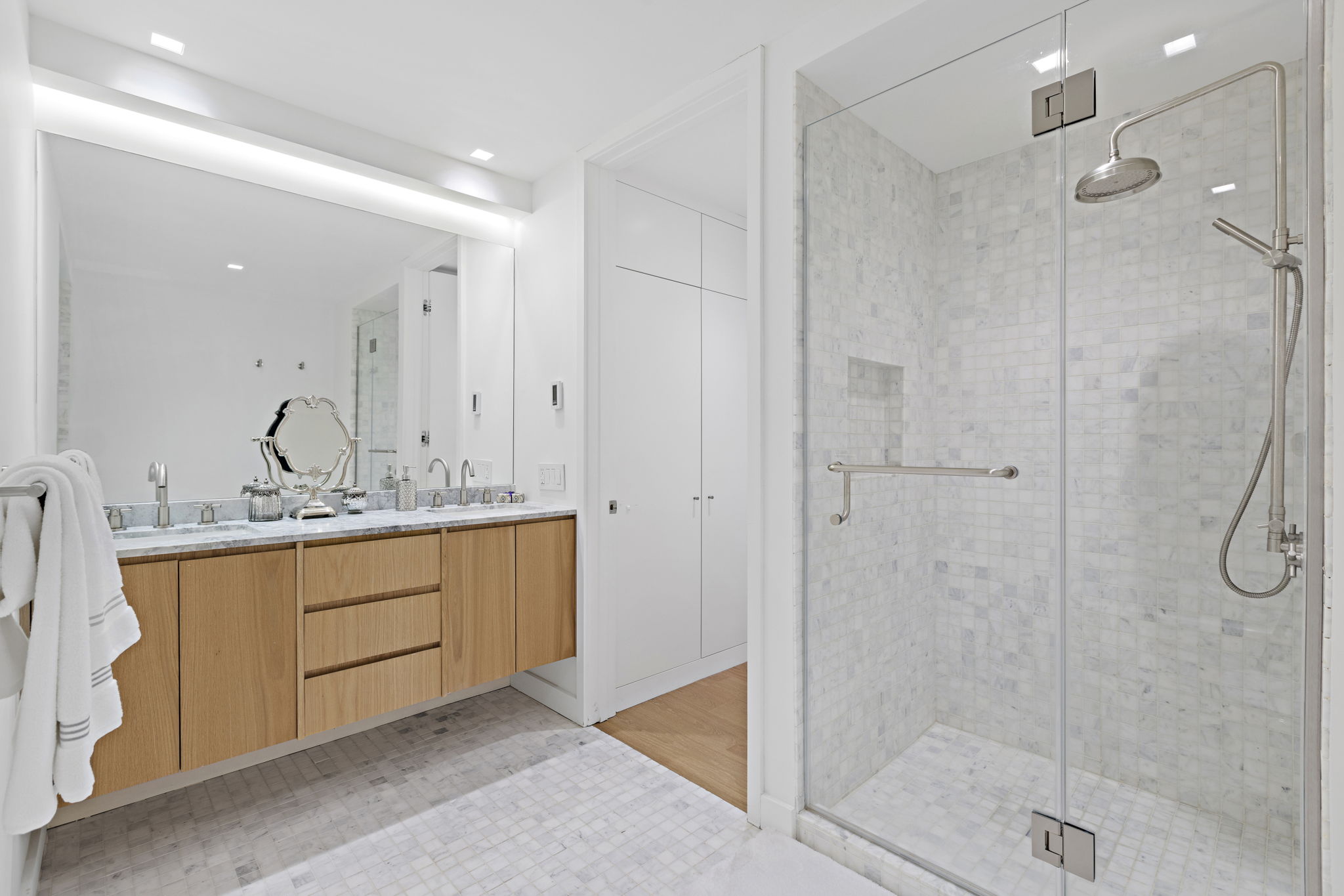 117 East 57th Street, Unit 21H Manhattan, NY 10022 - Photo 15 of 26 a bathroom with a granite countertop sink mirror and a shower