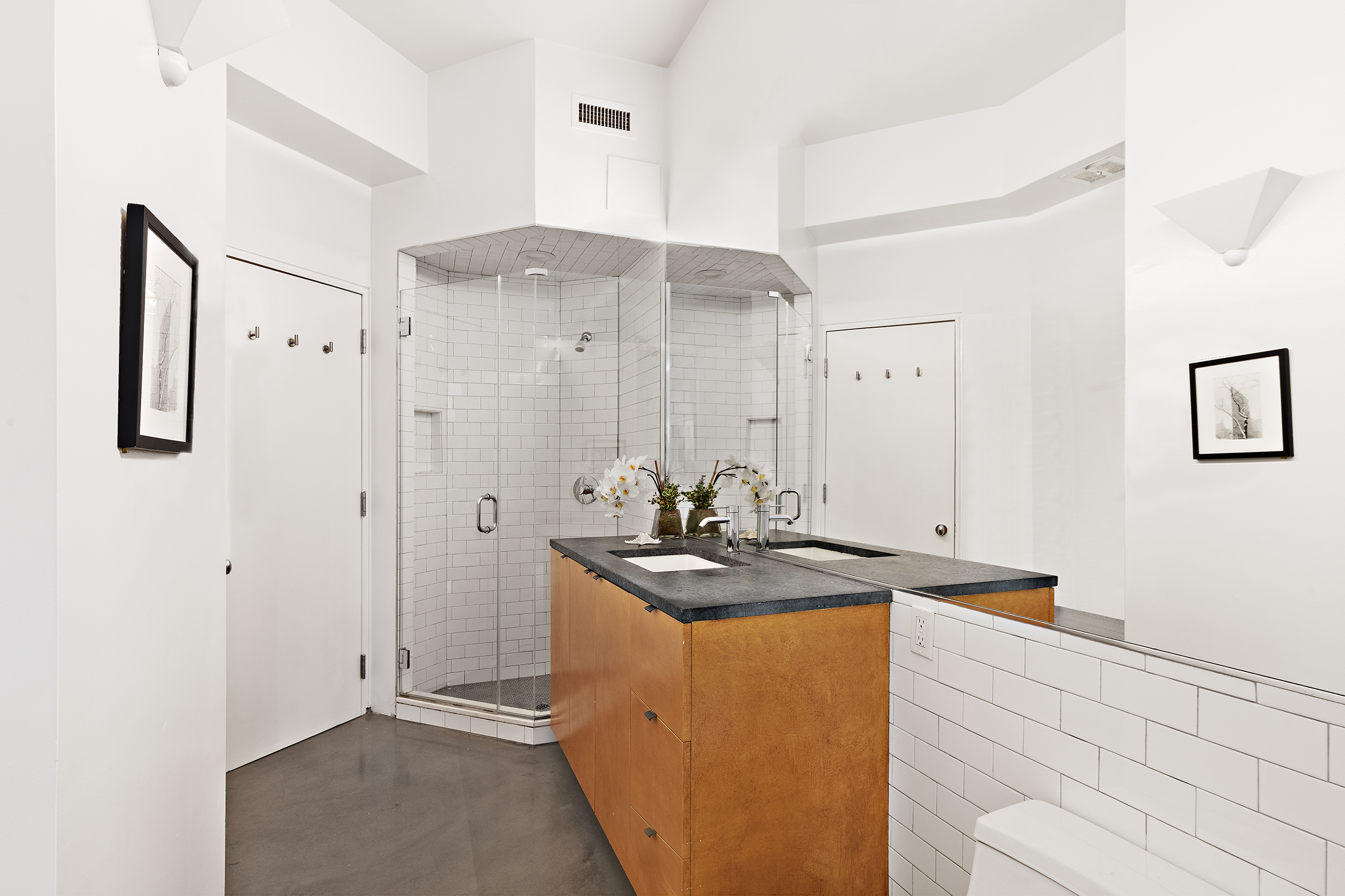 12 East 12th Street, Unit 5N Manhattan, NY 10003 - Photo 7 of 9 a bathroom with a granite countertop sink a mirror and shower