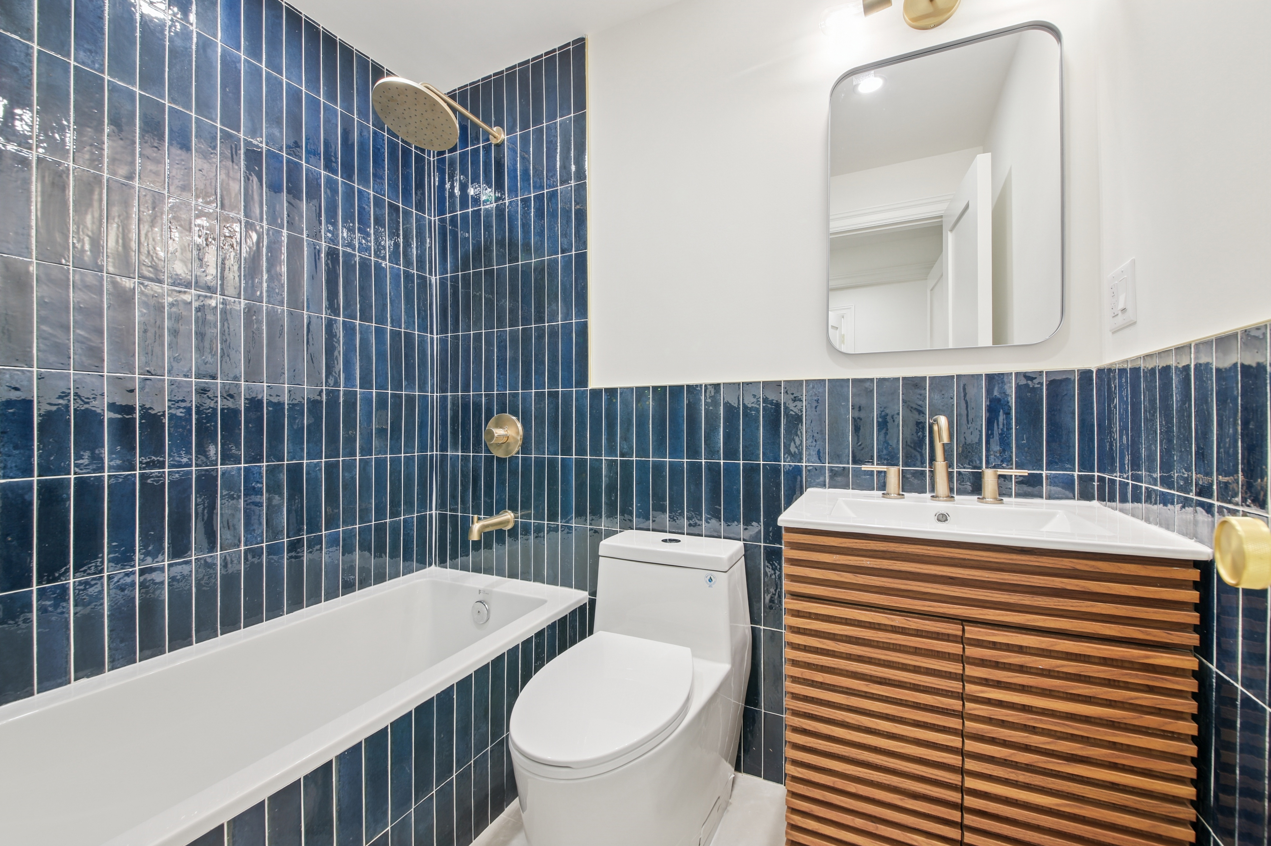 239 Madison Street, Unit 1 Brooklyn, NY 11216 - Photo 6 of 14 a bathroom with a sink toilet and mirror