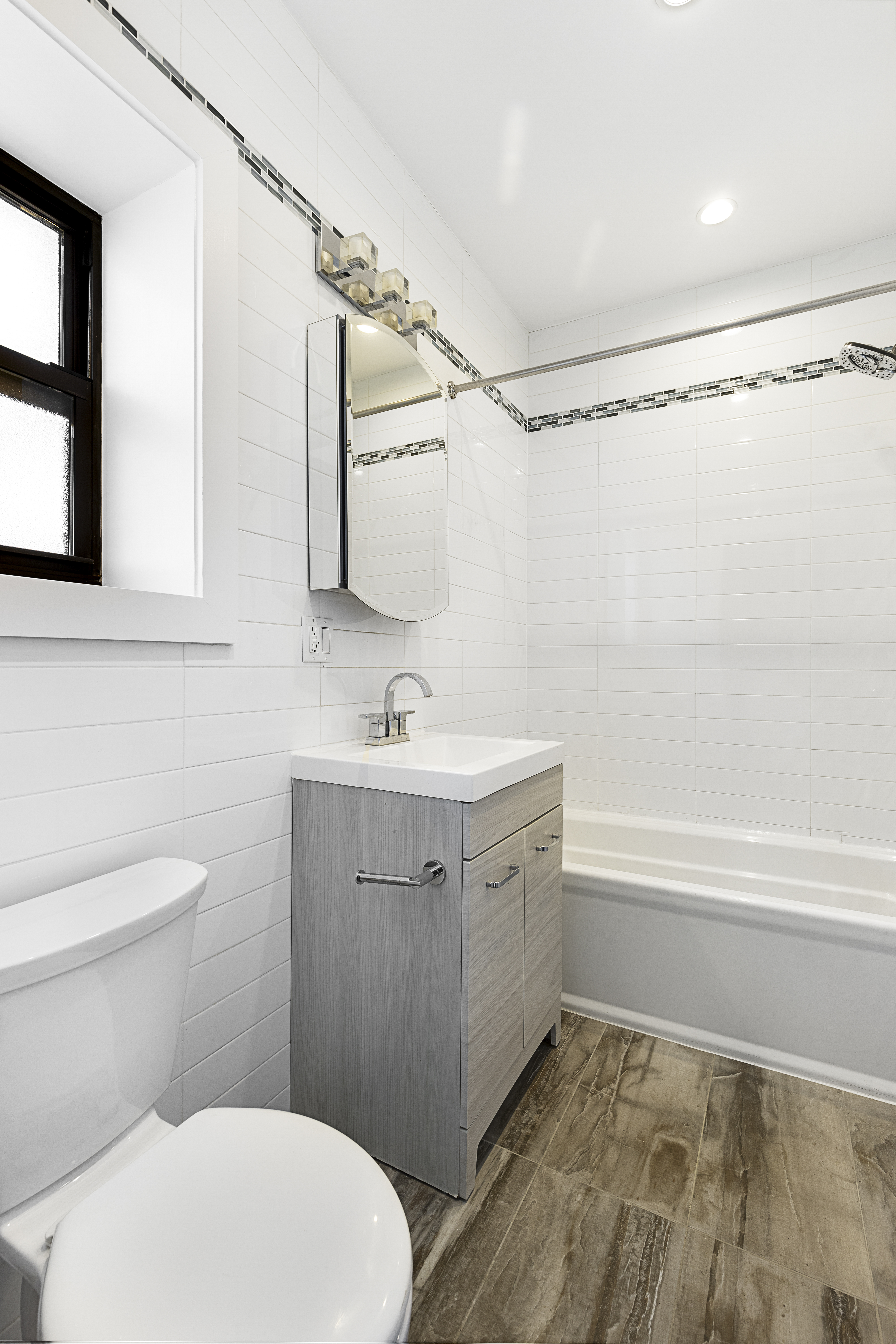 346 West 52nd Street, Unit 5D Manhattan, NY 10019 - Photo 4 of 7 a bathroom with a sink a toilet and shower