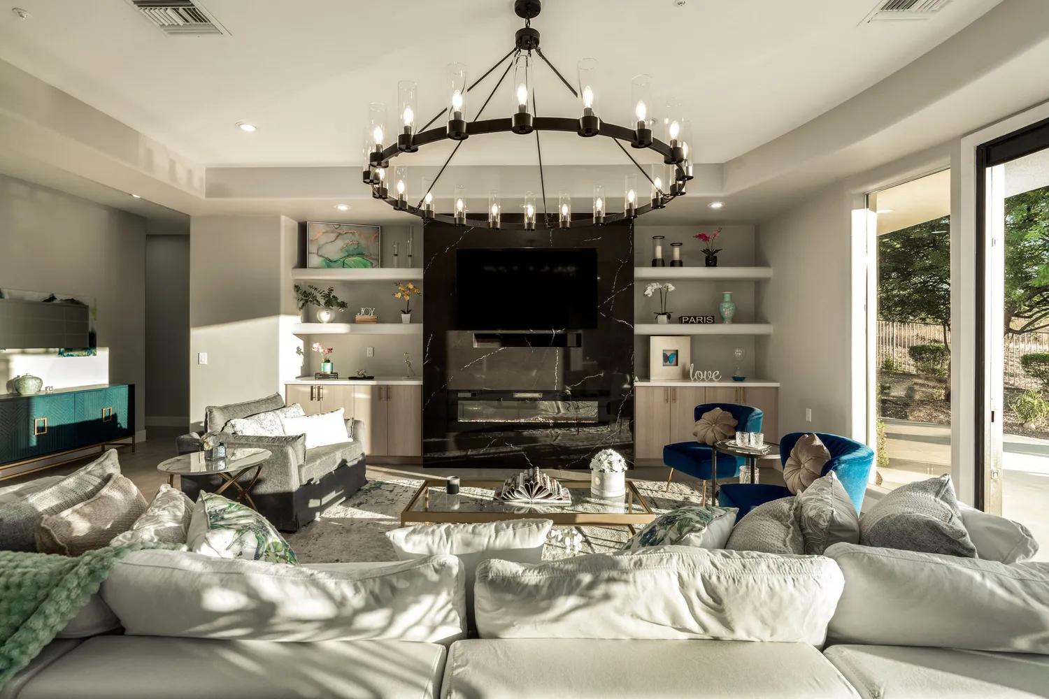 a living room with furniture kitchen view and a chandelier