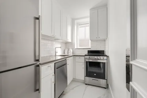 a kitchen with cabinets stainless steel appliances and a sink