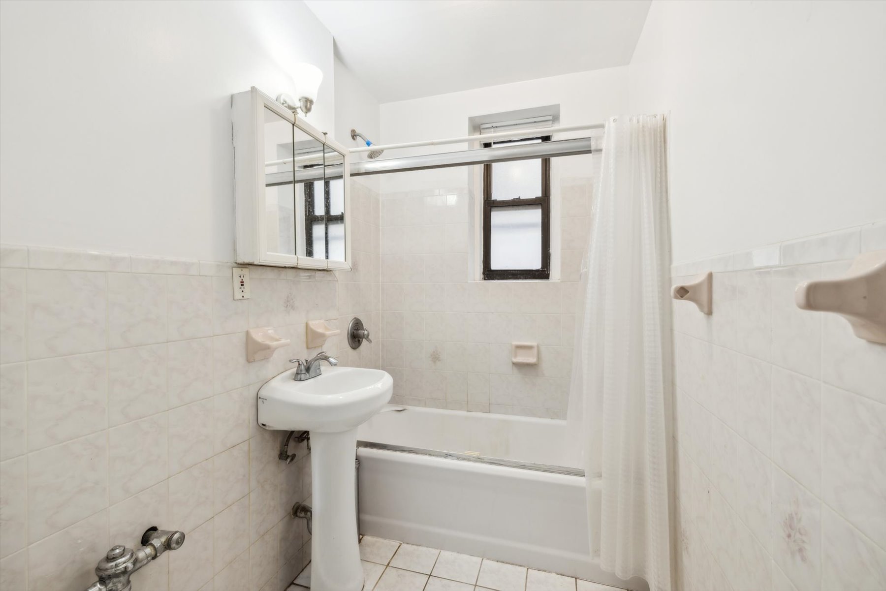 9701 Shore Road, Unit 1C Brooklyn, NY 11209 - Photo 7 of 8 a bathroom with a sink a mirror and a bathtub