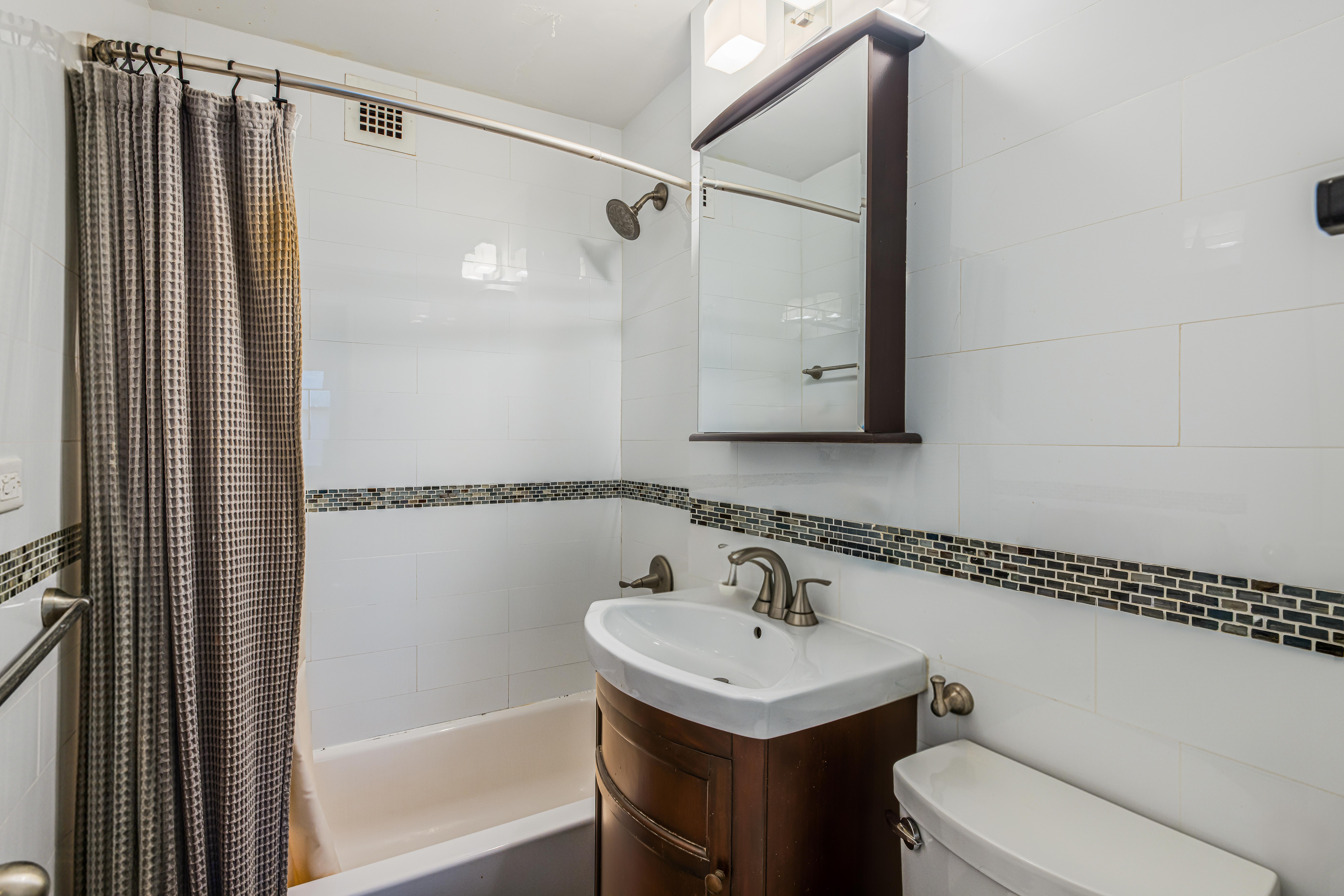 201 East 21st Street, Unit 3K Manhattan, NY 10010 - Photo 4 of 8 a bathroom with a sink toilet and shower