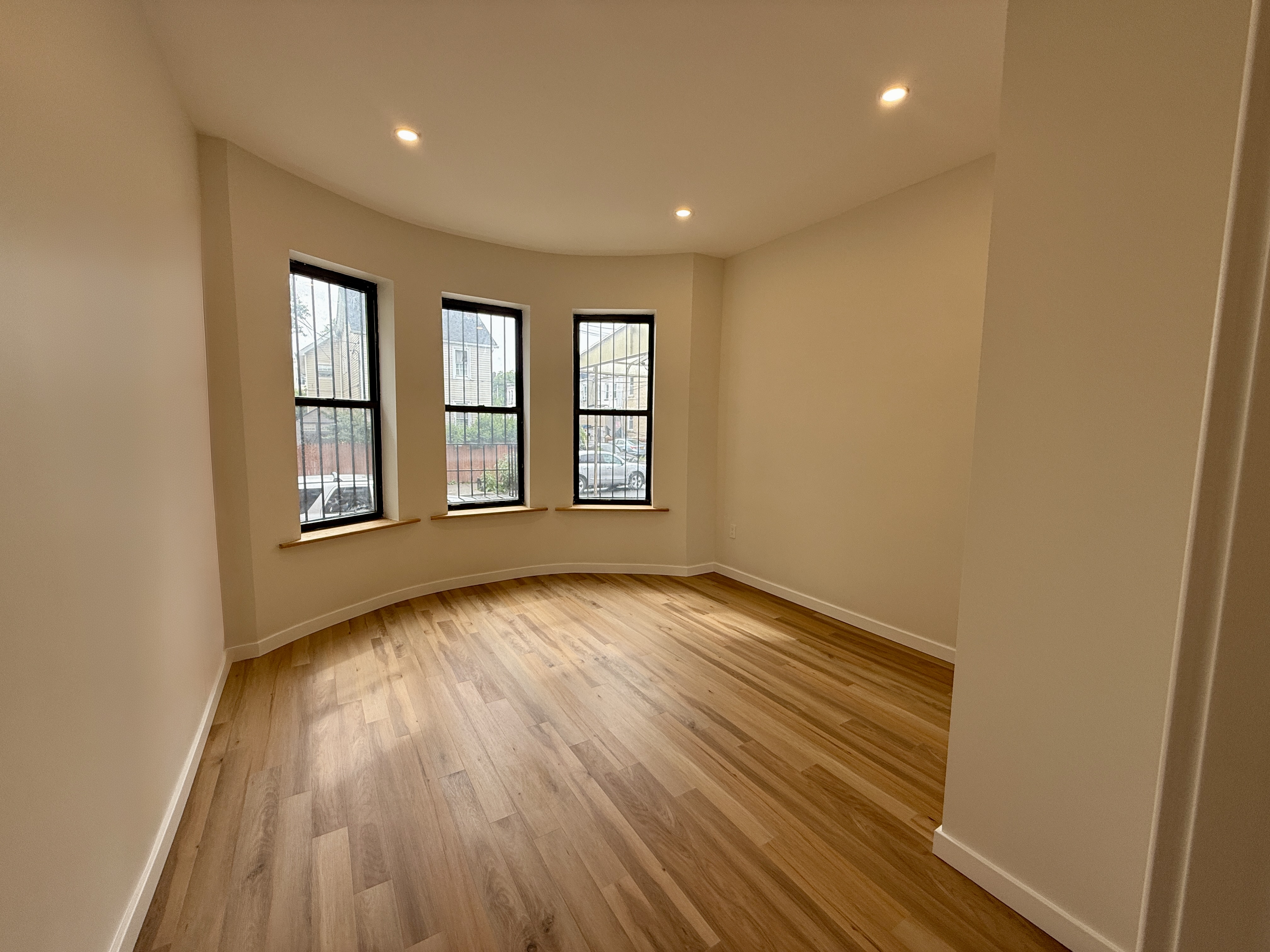 139 Autumn Avenue, Unit 1 Brooklyn, NY 11208 - Photo 8 of 14 a view of an empty room with wooden floor and a window