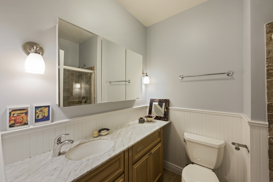 369 6th Avenue, Unit 2 Brooklyn, NY 11215 - Photo 5 of 9 a bathroom with a granite countertop toilet sink and mirror