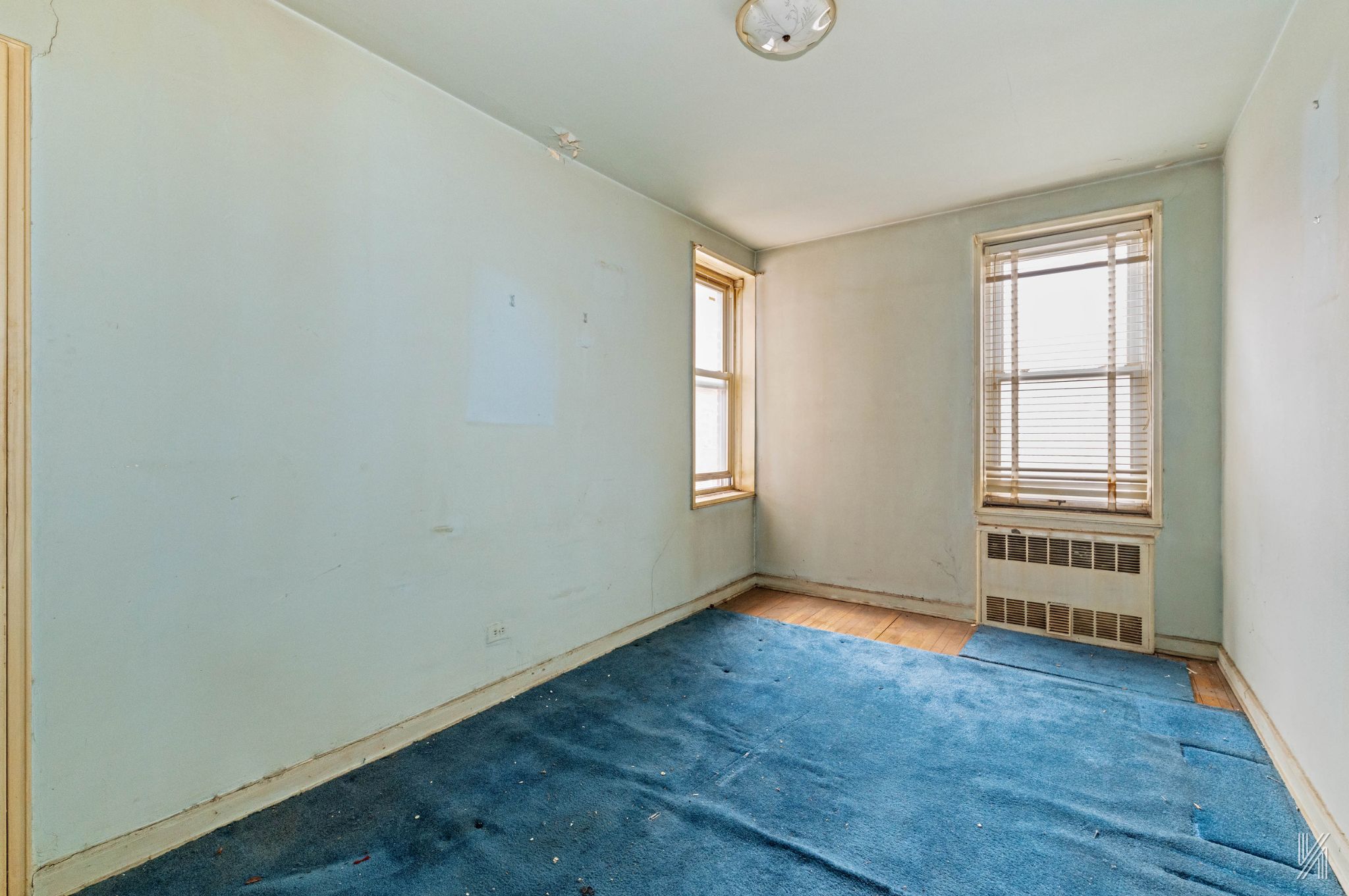 33-05 90th Street, Unit 4F Queens, NY 11372 - Photo 12 of 18 an empty room with wooden floor and windows