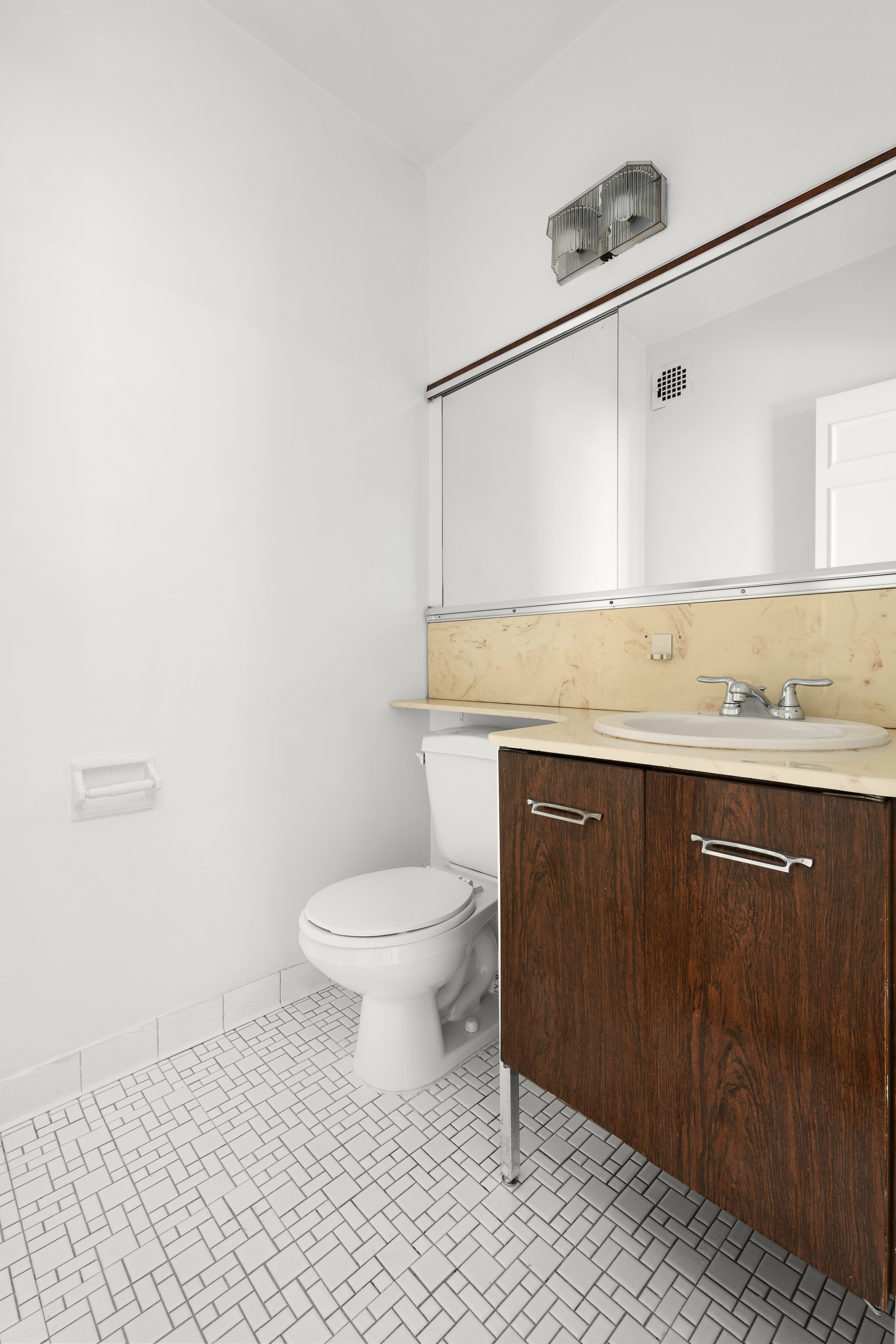 300 East 74th Street, Unit 20E Manhattan, NY 10021 - Photo 6 of 14 a bathroom with a granite countertop sink a toilet and mirror