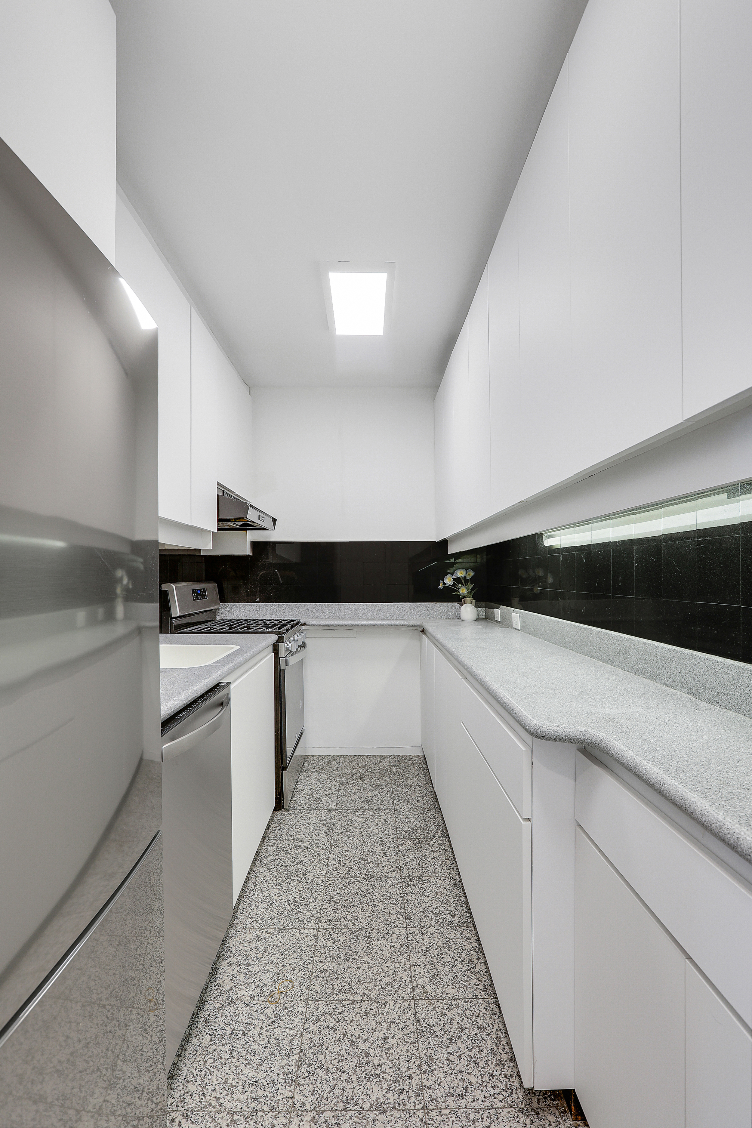 300 East 33rd Street, Unit 21K Manhattan, NY 10016 - Photo 8 of 17 a kitchen with a sink and white cabinets