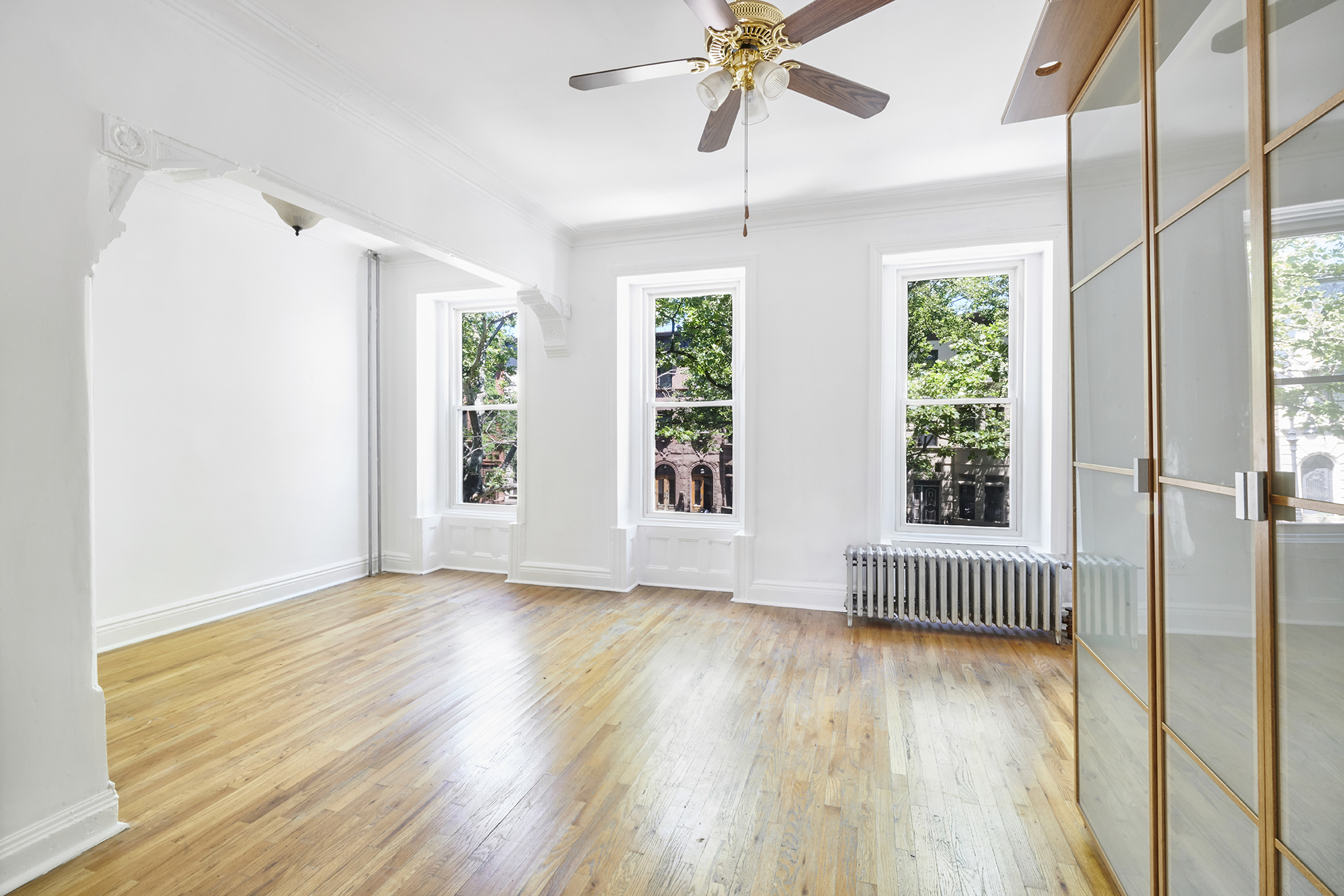 276 Stuyvesant Avenue, Unit 2 Brooklyn, NY 11221 - Photo 4 of 11 a view of an empty room with wooden floor and a window