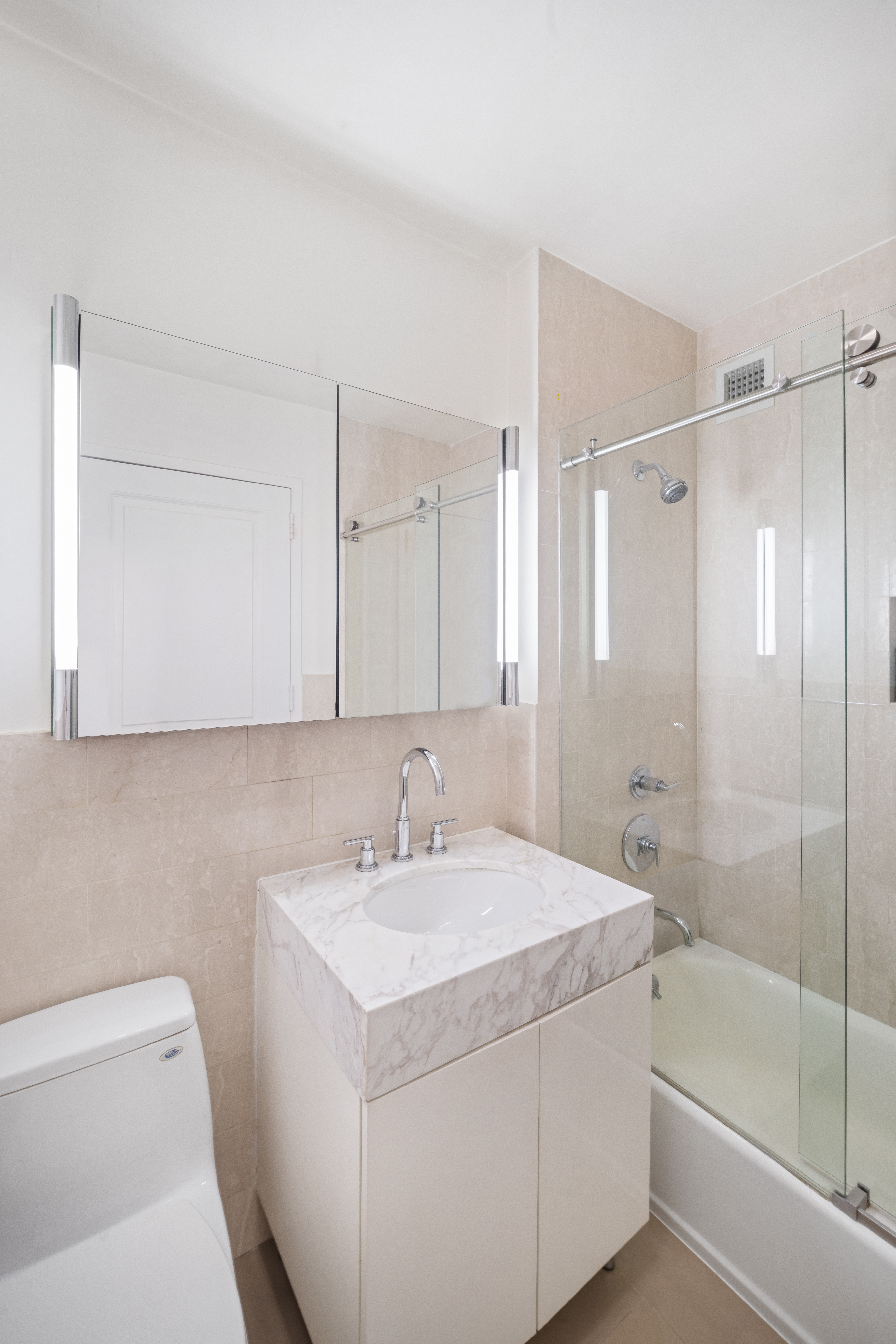 300 East 64th Street, Unit 11D Manhattan, NY 10065 - Photo 4 of 17 a bathroom with a sink a toilet and shower