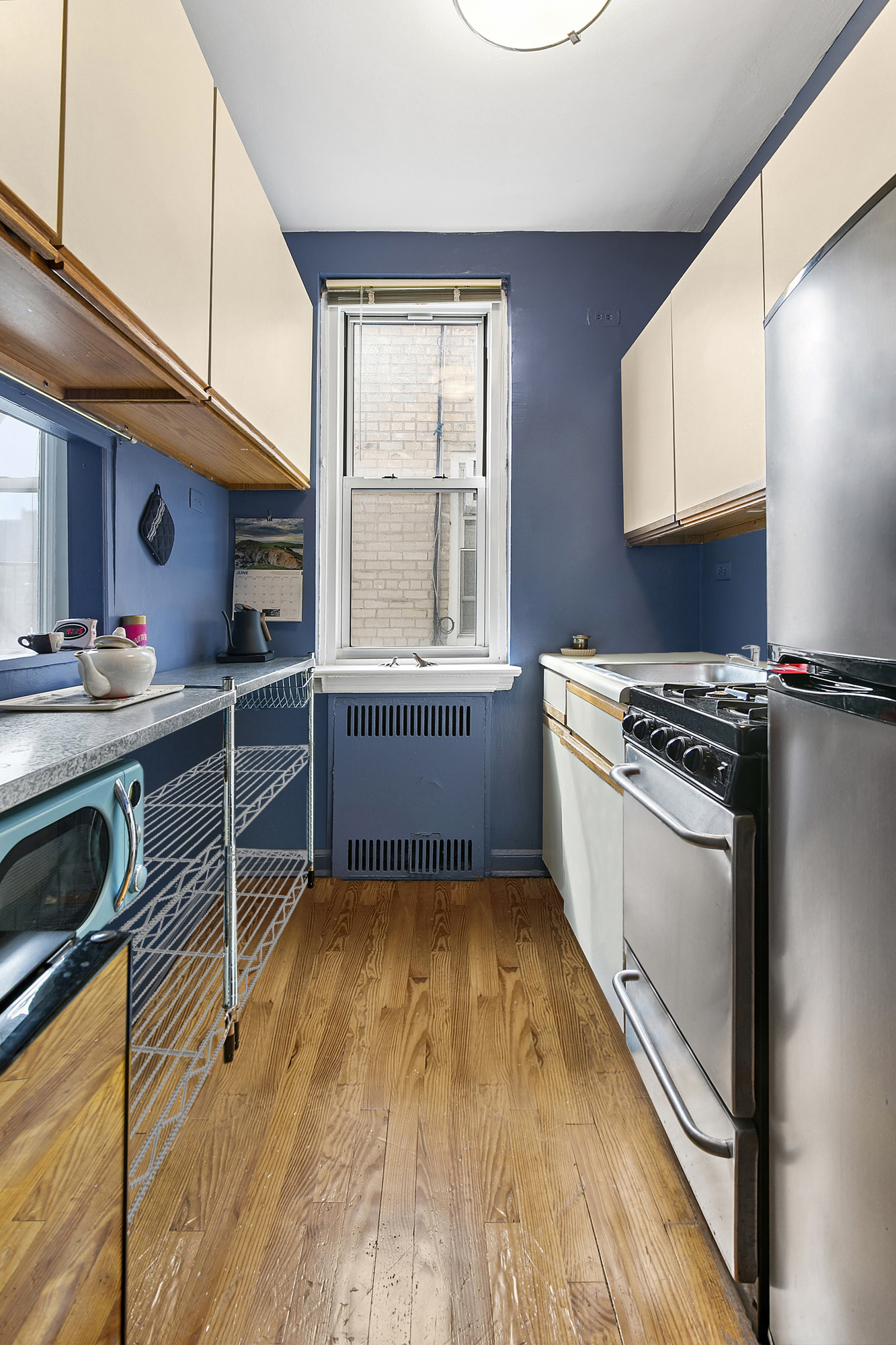 310 West 55th Street, Unit 6K Manhattan, NY 10019 - Photo 4 of 7 a kitchen with wooden floors and a stove